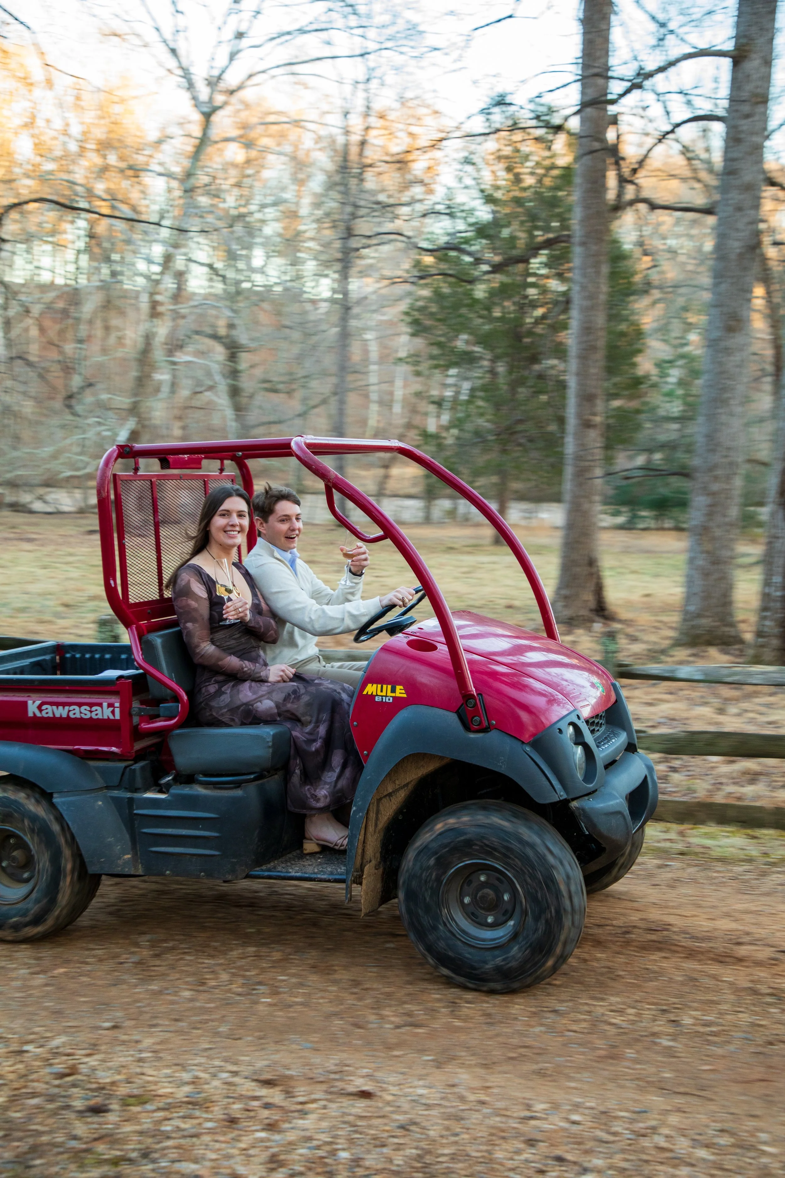 Engagement Photography by Will Locke near Richmond, VA in Montpelier. A newly engaged couple riding a red Kawasaki Mule utility vehicle.