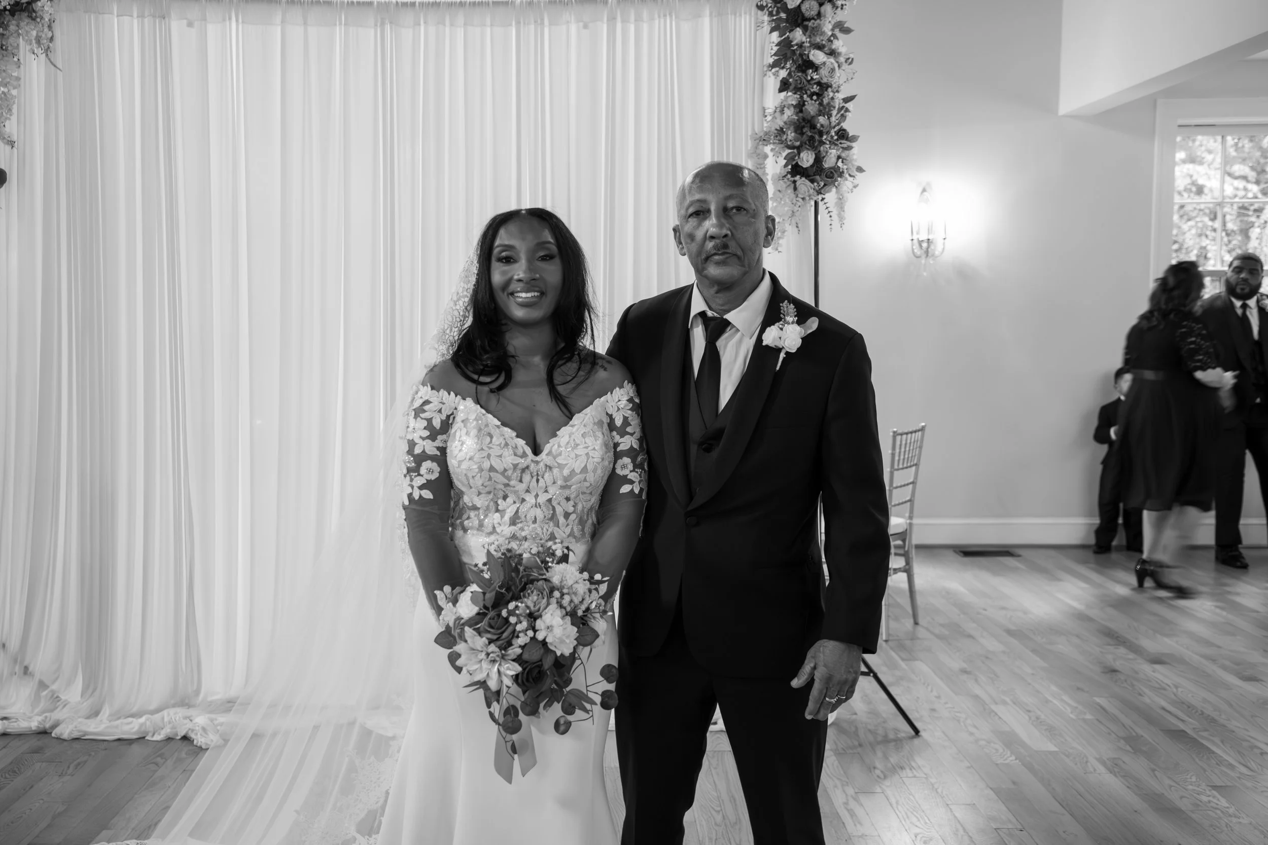 A bride and an older man, possibly her father, posing together at a wedding reception, smiling. Photo & Video by Will Locke Wedding Photography at the Woman's Club of Portsmouth in Virginia. 