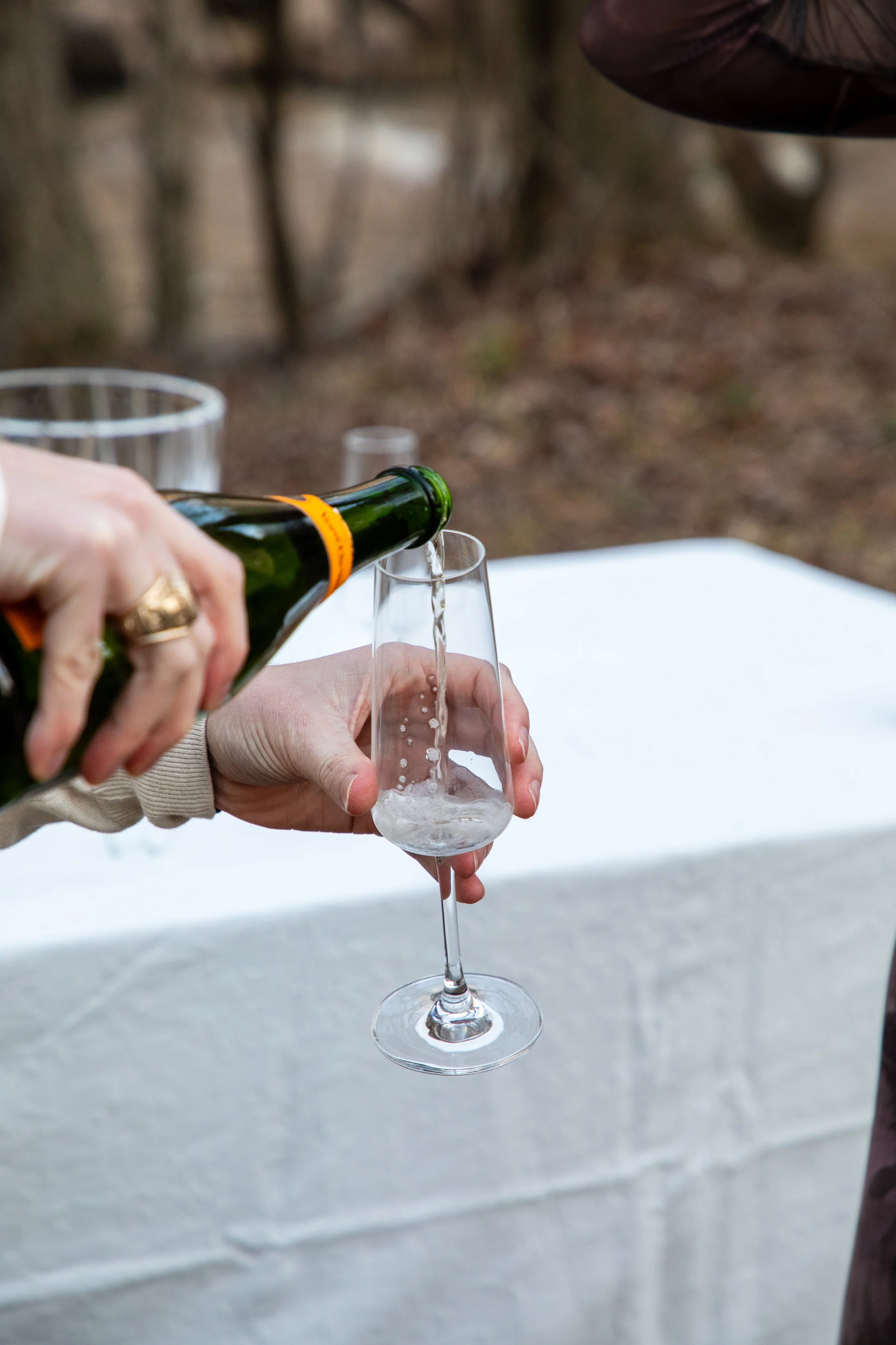 Engagement Photography by Will Locke near Richmond, VA in Montpelier. A champagne glass is being poured, with a table and a bottle of champagne in the background.