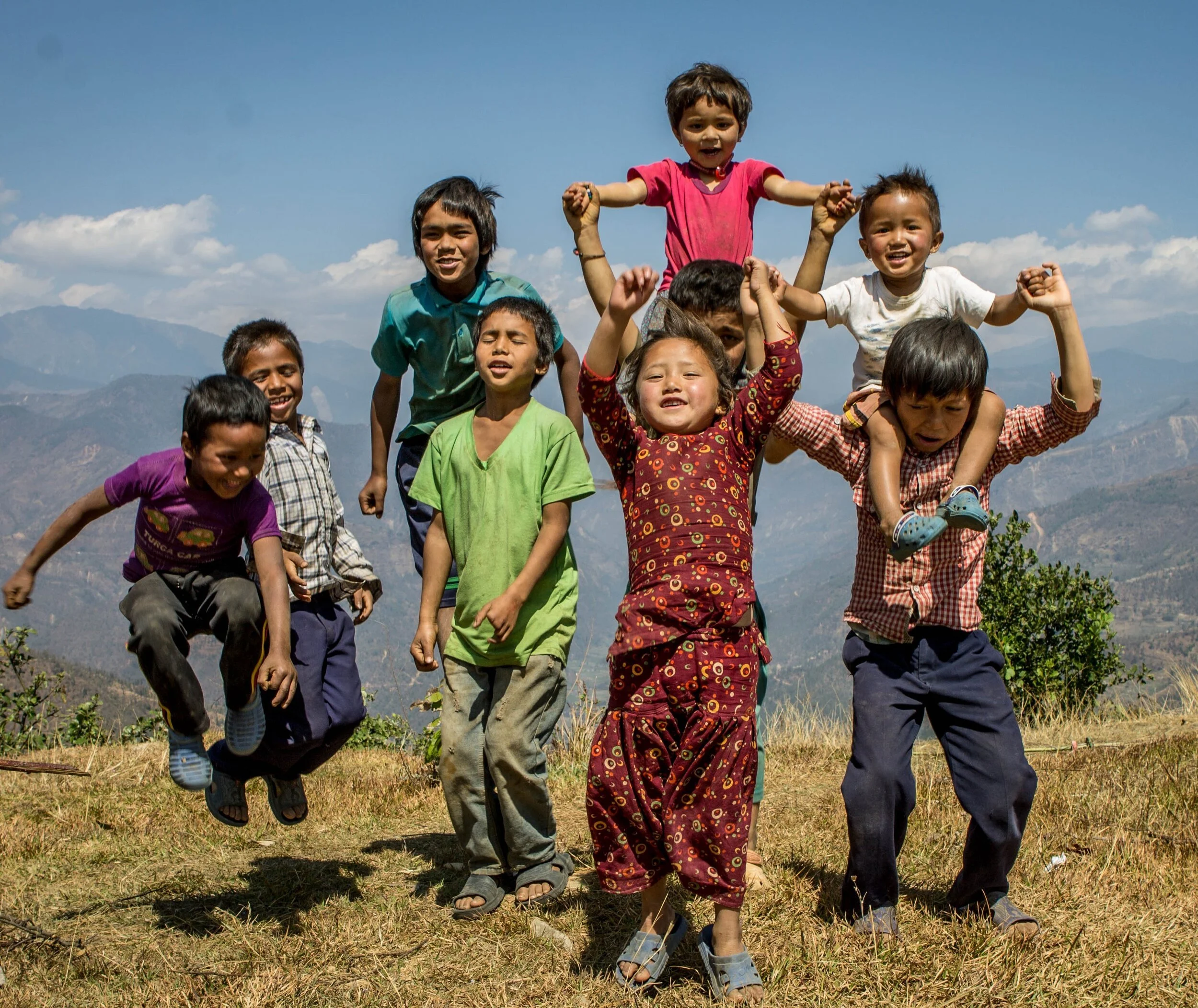 Image c/o First Steps Himalaya of local Nepalese children dancing above a valley.