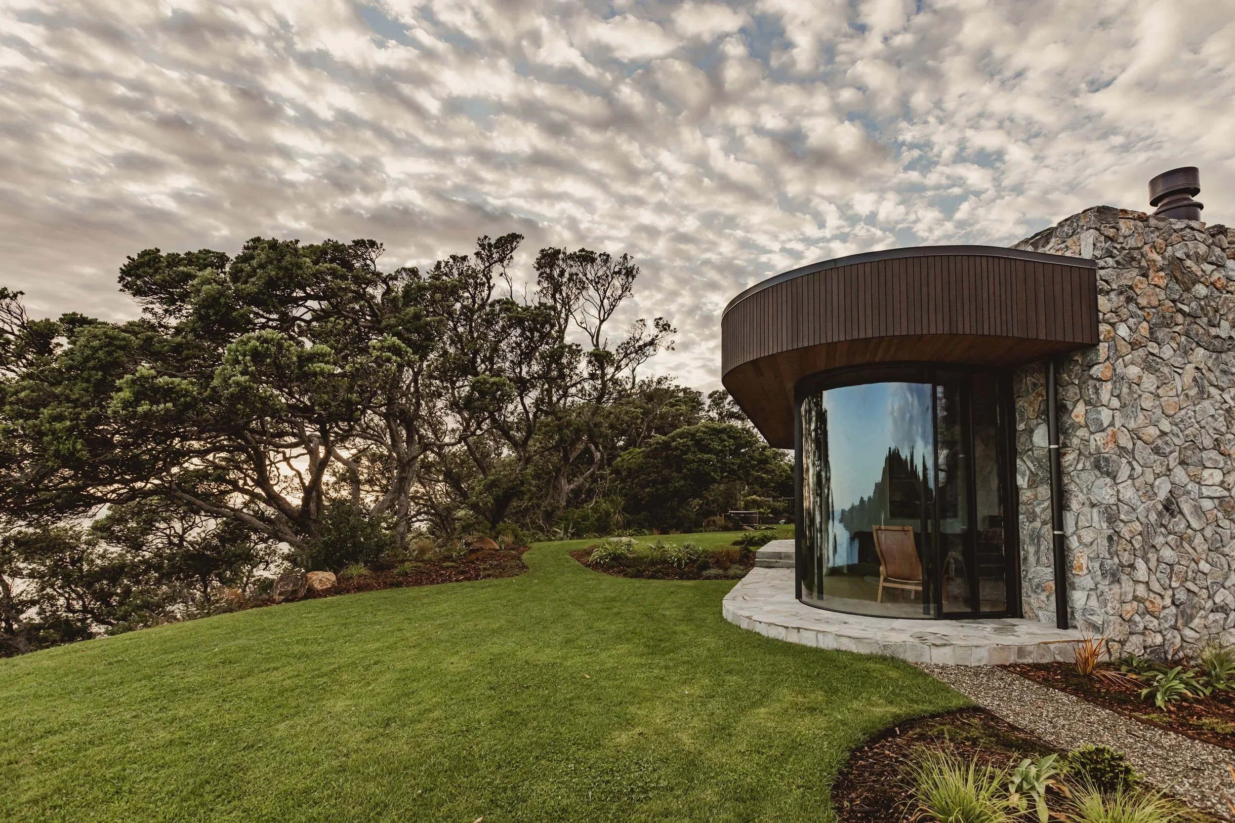 Curved parapet capping and window flashings visible around roof of Ti Point House, a Lindesay / Construction Crosson Architects / Rochford Landscapes project where Swift Roofing installed RT7 Roof in ColorCote Horoeka coloured MagnaFlow from Roofing 