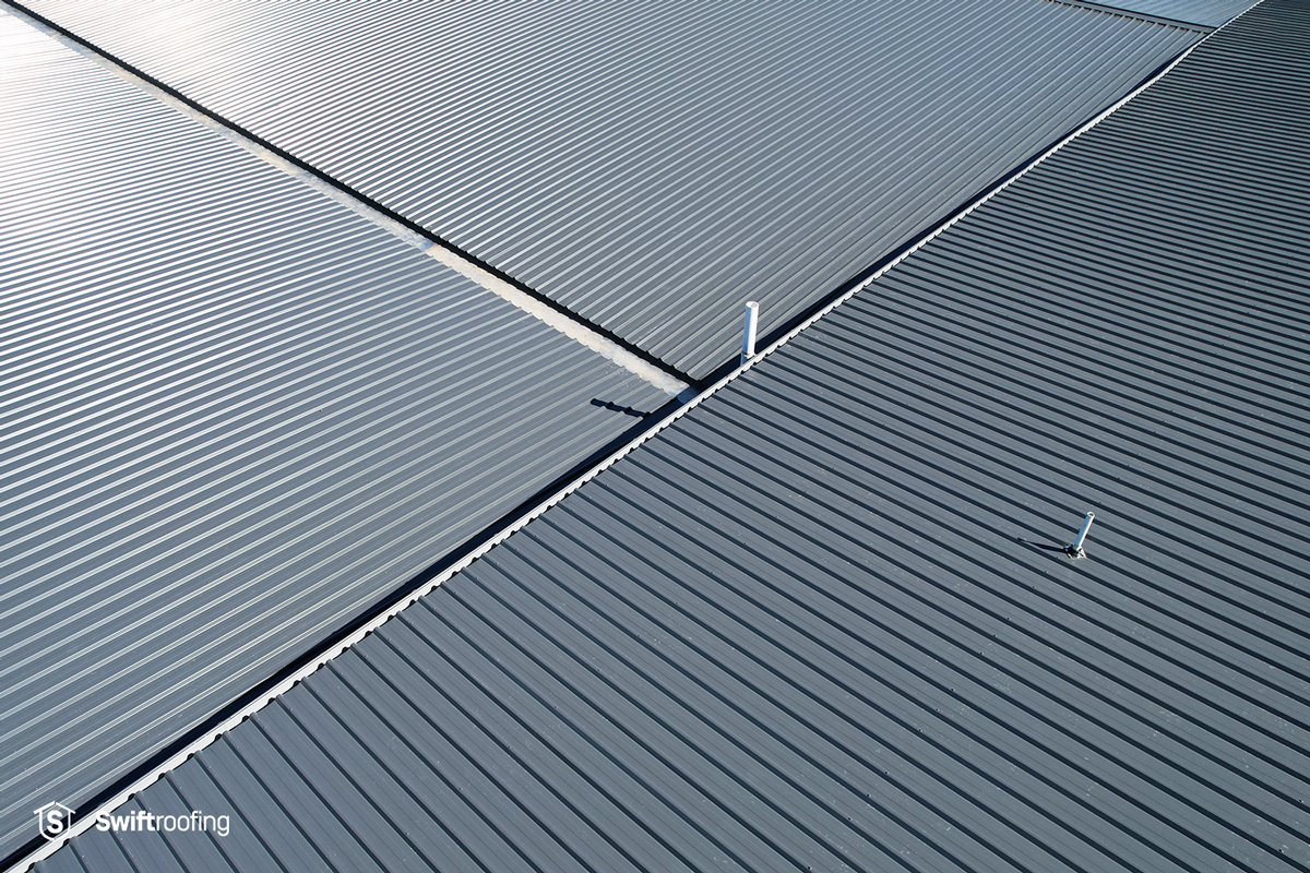 Closer detail top down drone view of Three Kings Commercial Roof Replacement where Swift Roofing replaced the old, rundown roof with new ZinaCore coated Grey Friars Trimrib profile roofing.