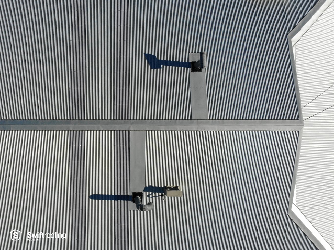 Drone zoomed in view directly down on The Wairau Paint Centre new commercial roof that Swift Roofing installed with Corrugate and Corrugate Topglass, in Wairau Valley