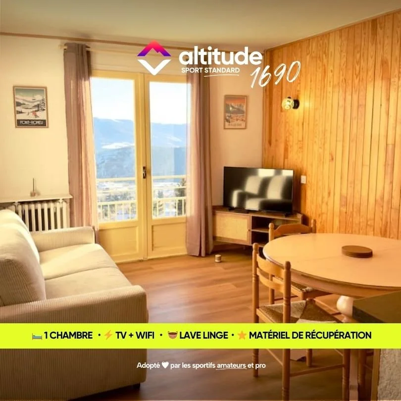 Intérieur d'une chambre avec vue sur les montagnes, un téléviseur, un sofa, une table ronde en bois, et un balcon. Texte promotionnel pour un hébergement pouvant accueillir jusqu'à 6 personnes, avec une chambre, la télévision, le Wi-Fi, et une lave-linge.