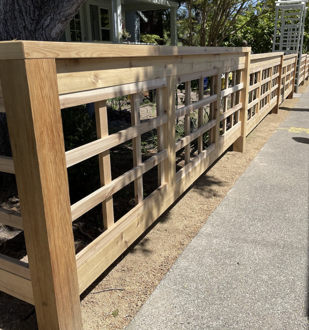 Wooden lattice fence along a sidewalk