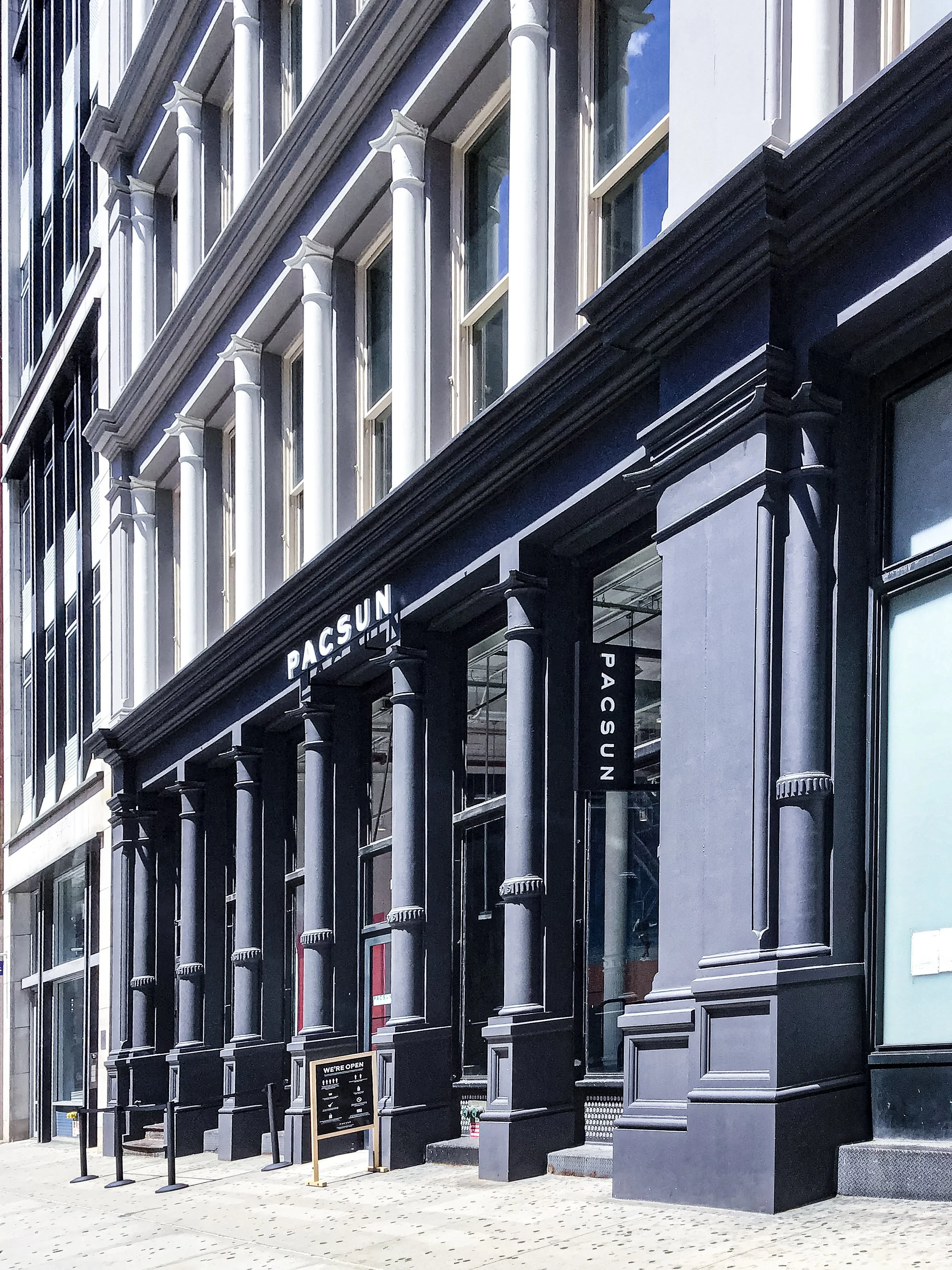 503-511 Retail Facade - City building with black painted facade, large columns, and a sign that reads 'PACSUN'.