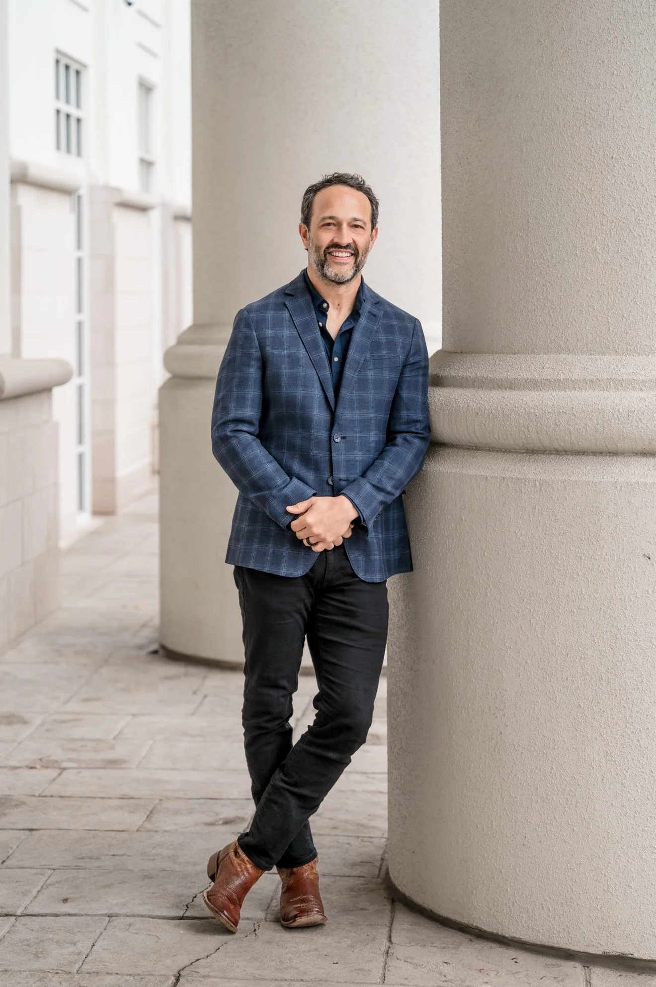 Jeff Hopeck, speaker, in a blue plaid blazer leaning on a column
