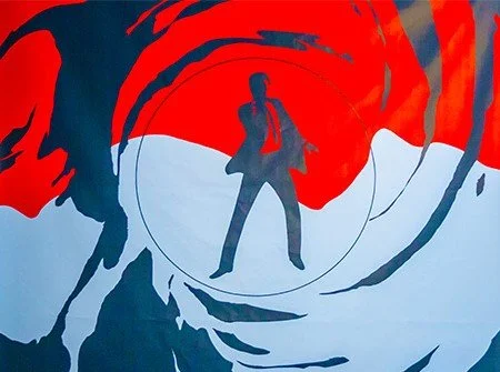 Silhouette of a person standing in the center with a background of spiral patterns in red, blue, and white.