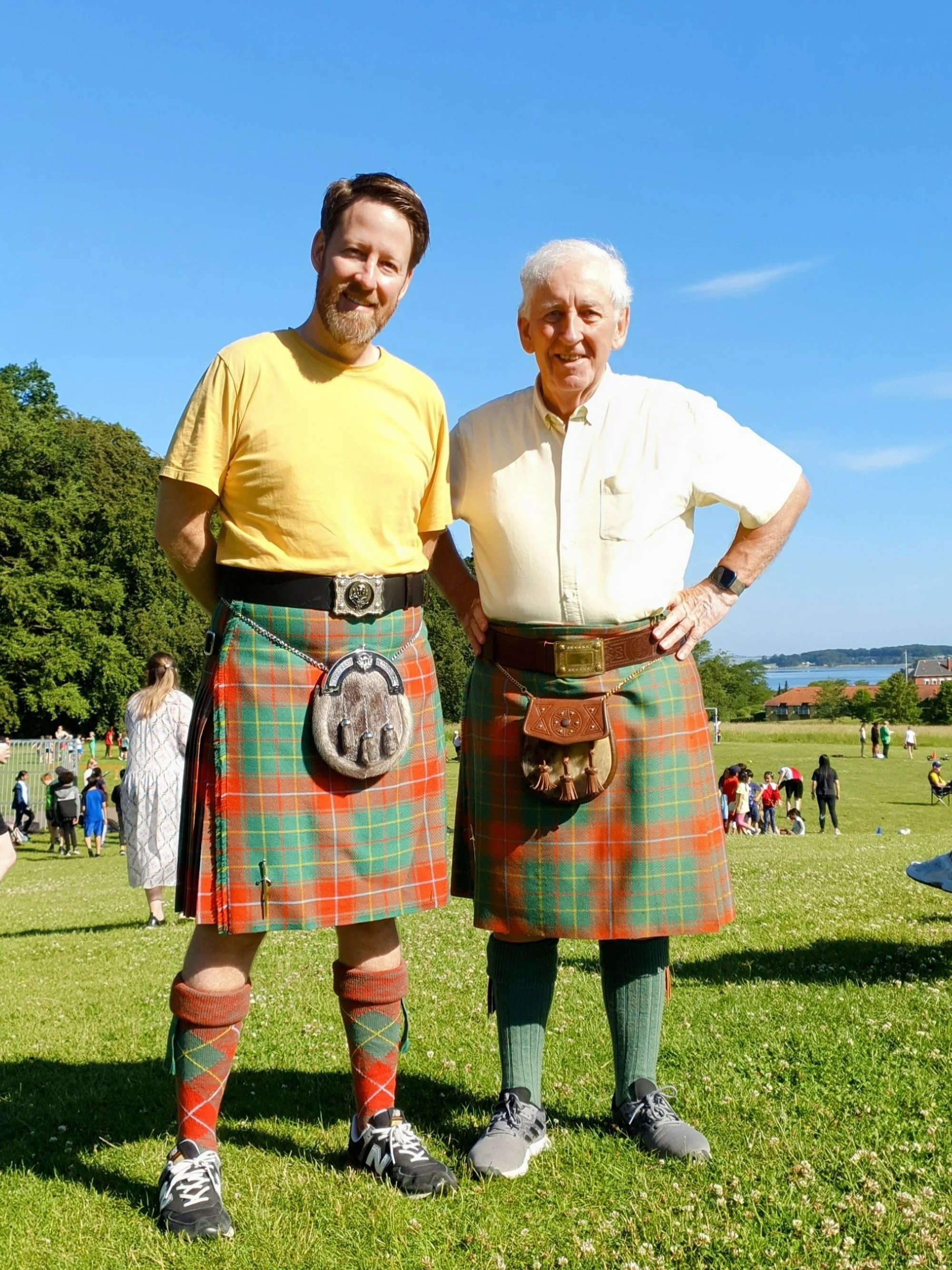 To mænd i traditionelt skotsk kilt i solskinsvejr i Folkeparken Roskilde