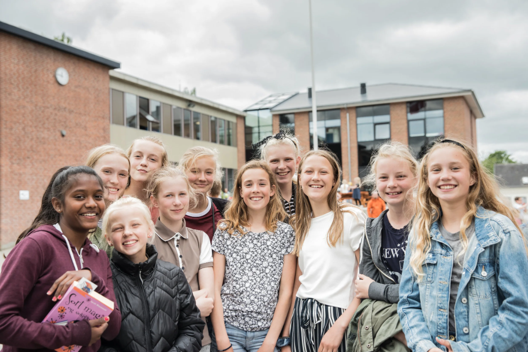 Gruppebillede af smilende elever fra udskolingen foran Skt. Josefs Skole i Roskilde