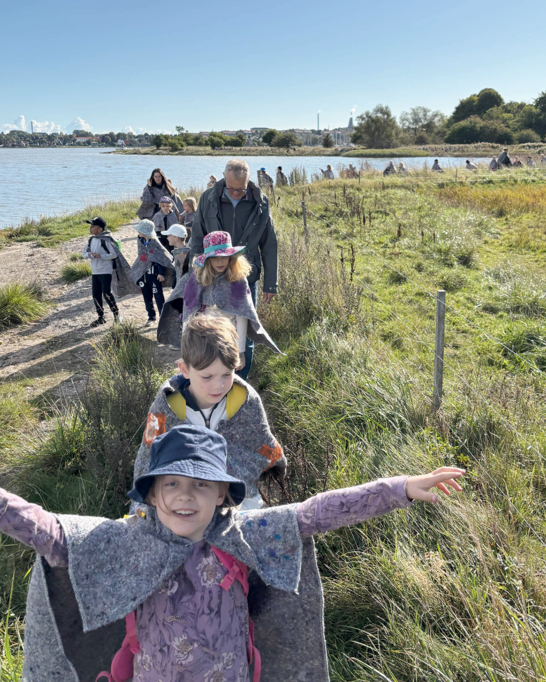 Elever og lærere går i flok på en naturskøn sti i Kællingehaven langs Roskilde Fjord