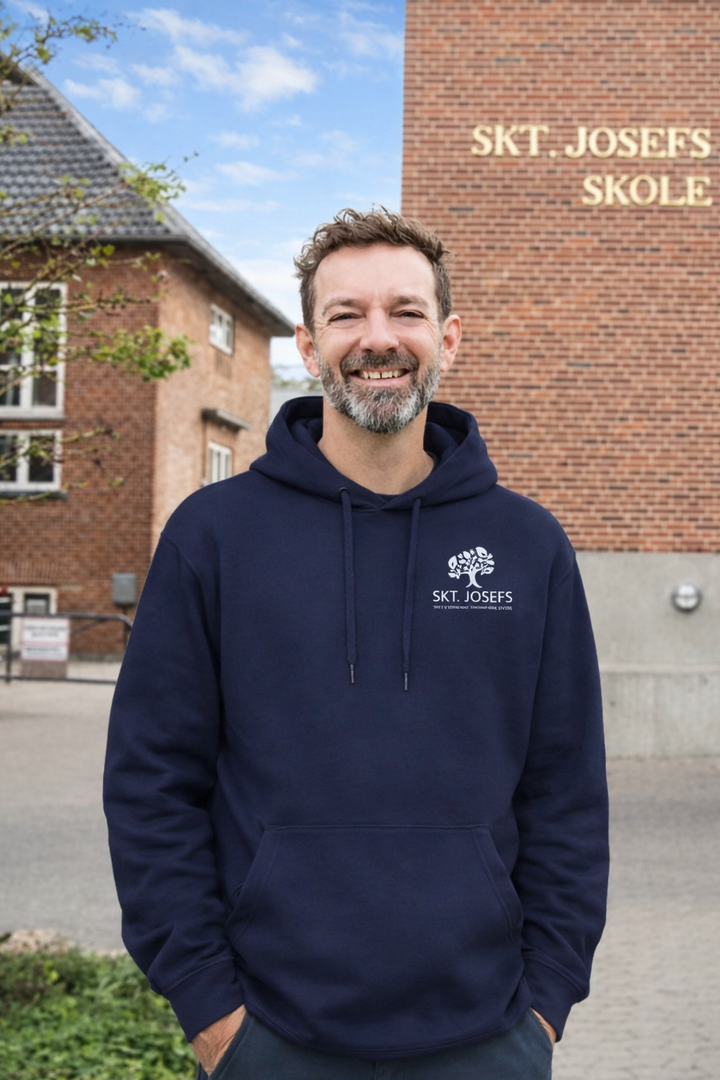 Skoleleder Martin Falkenberg Kofoed i hoodie med skolens logo foran Skt. Josefs Skole
