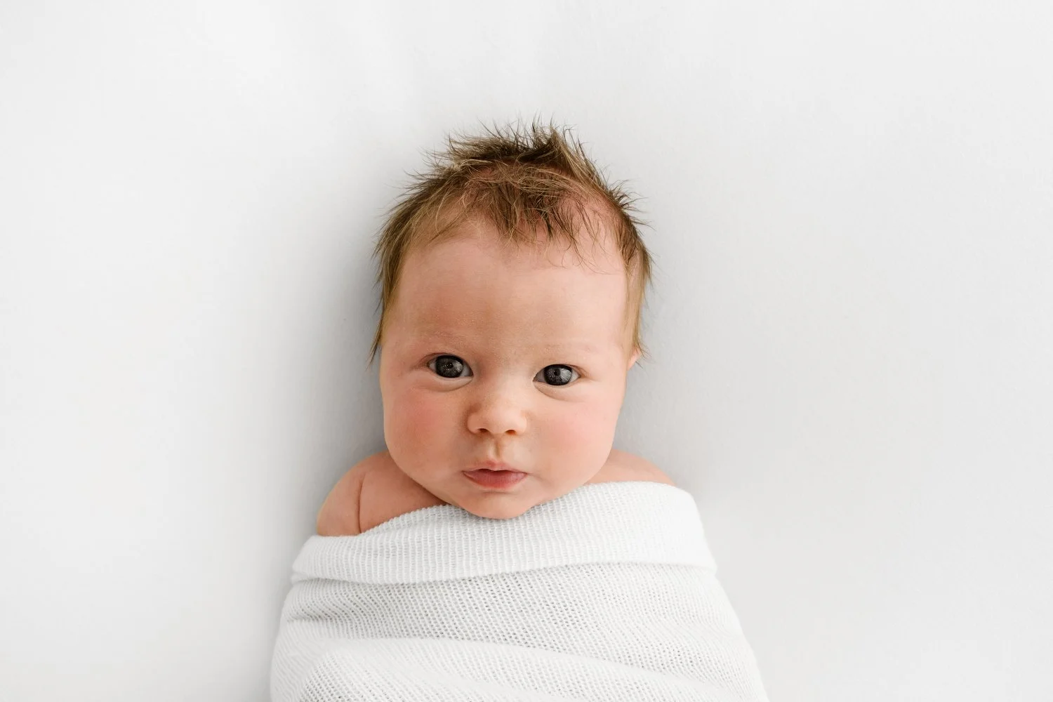 Natural style baby photography business. an awake newborn on white