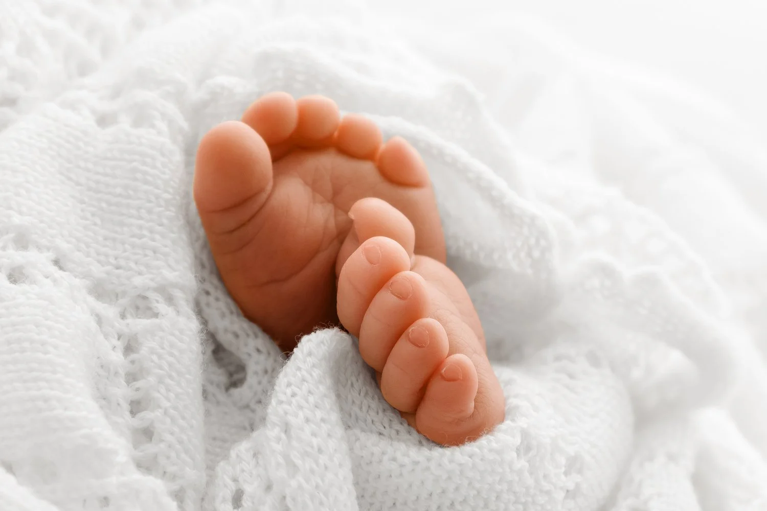 Tiny toes and delicate newborn details, showing sharp focus and soft background