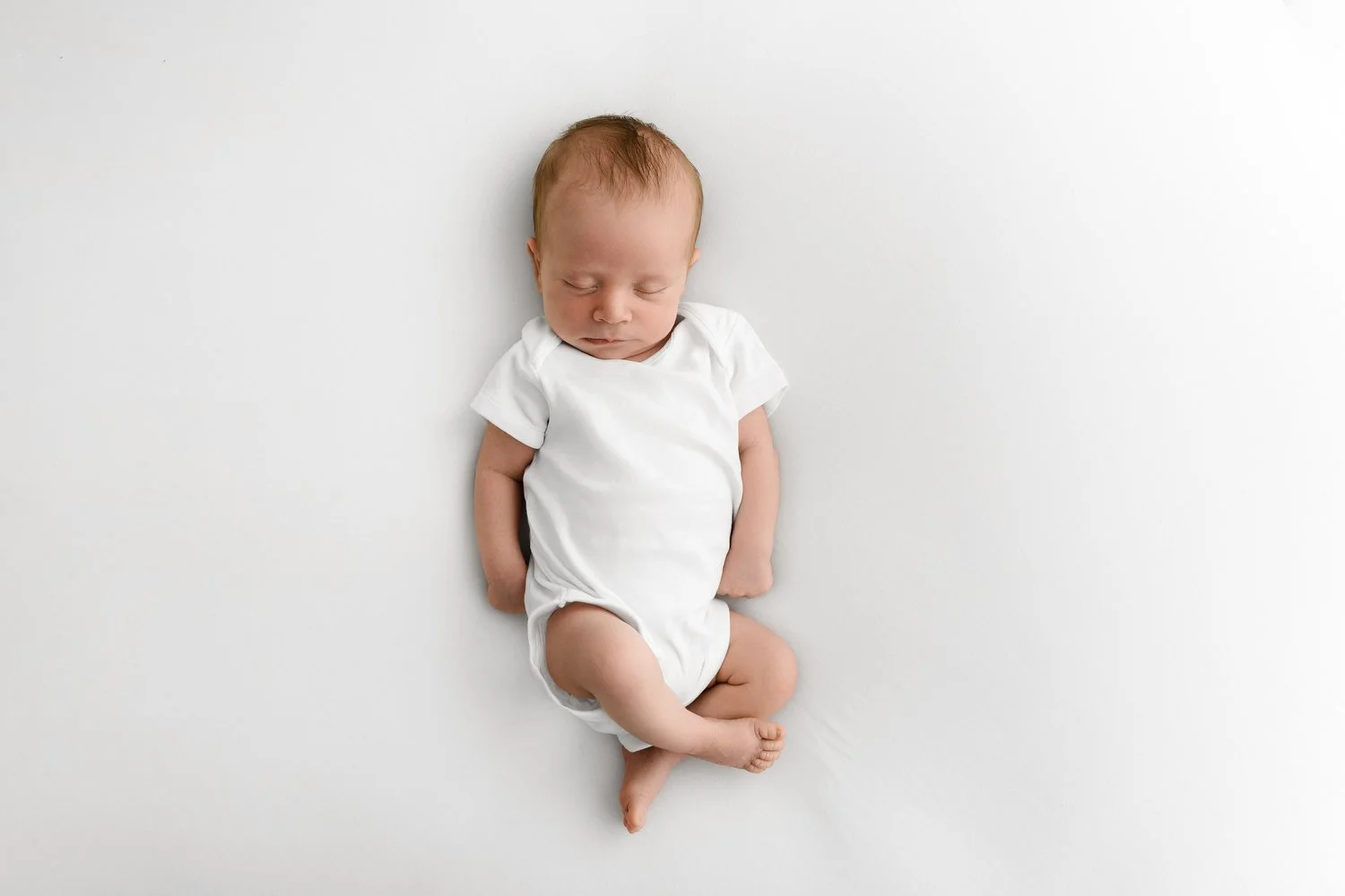 Naturally posed newborn baby gently curled at Mabel and Moose studio by Ally Stuart-Ross