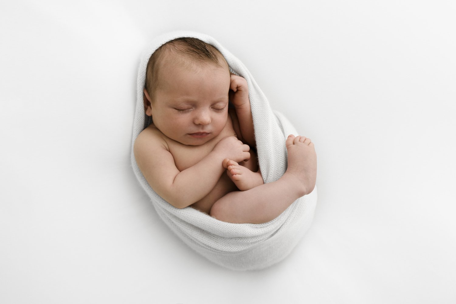 newborn baby wrapped in cocoon for training workshop. baby is sleeping