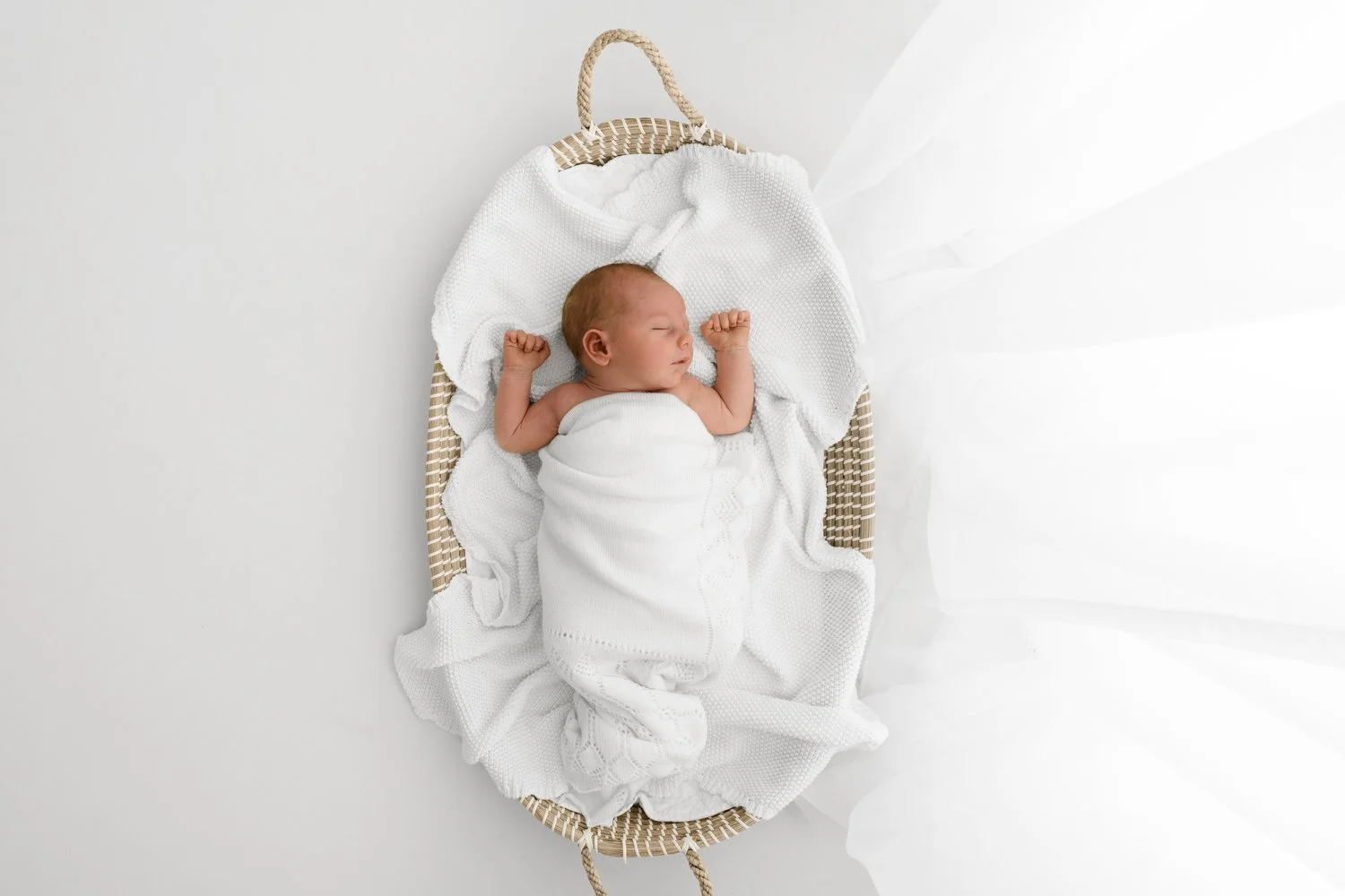 Overhead shot of sleeping newborn baby in natural seagrass changing basket lifestyle newborn photography