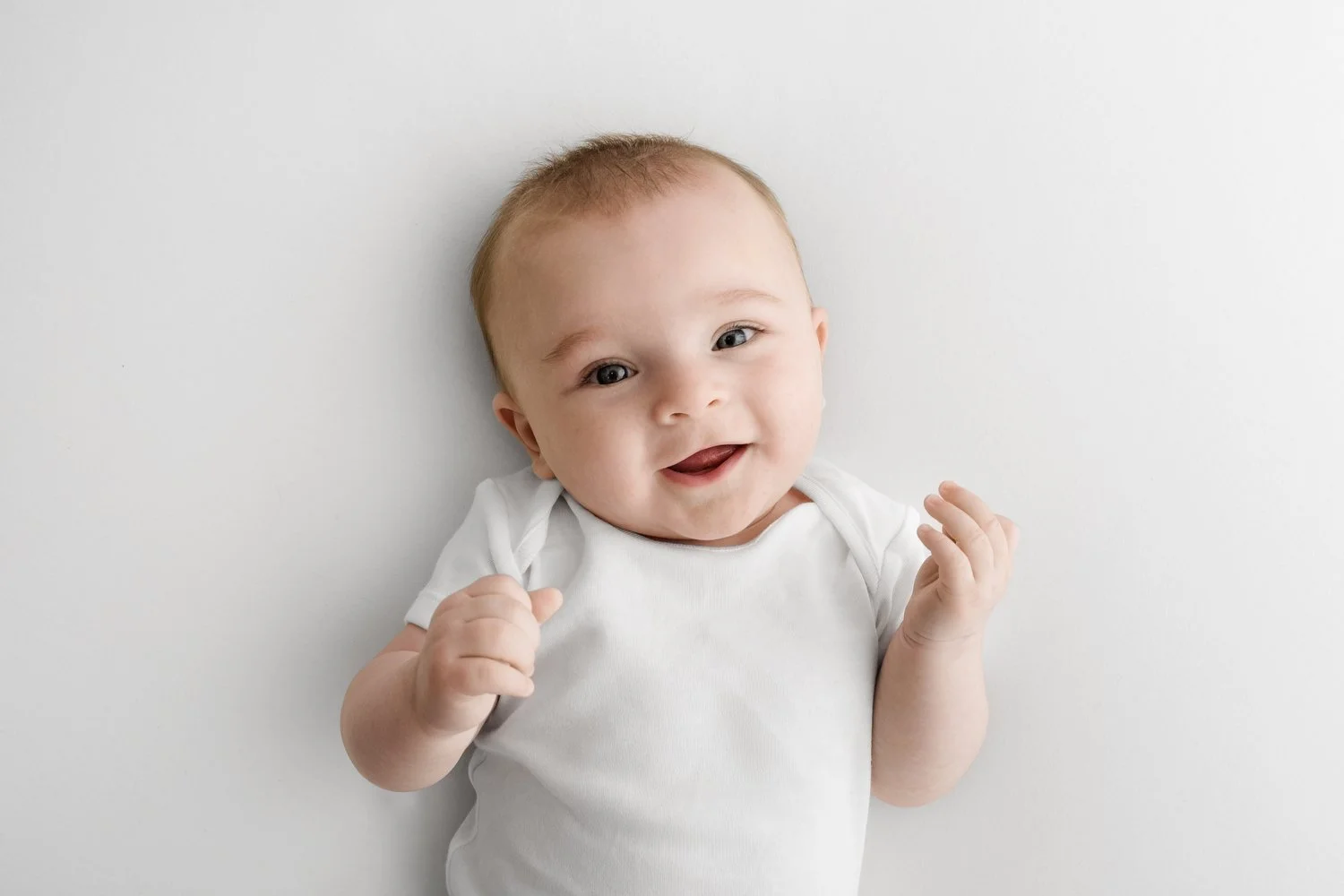 baby smiling in white vest and in soft natural style