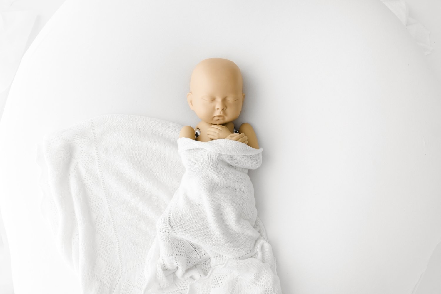 StandInBaby positioned on a beanbag during newborn photography training to practise wrapping and safe handling techniques