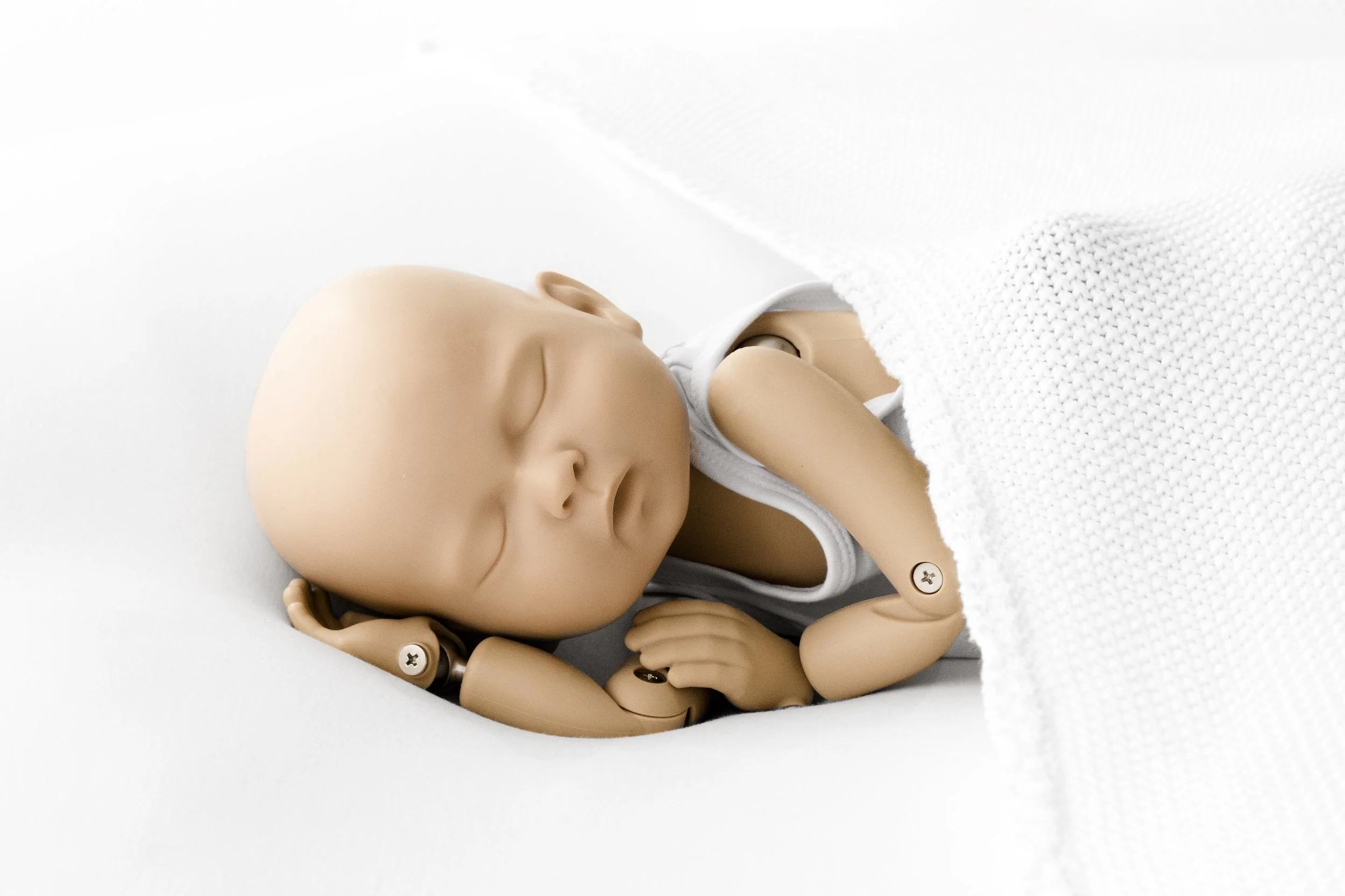 A beautifully styled final photograph of a StandInBaby realistic newborn training doll captured as though it were a real sleeping newborn demonstrating the skill and precision of the Mabel and Moose Method