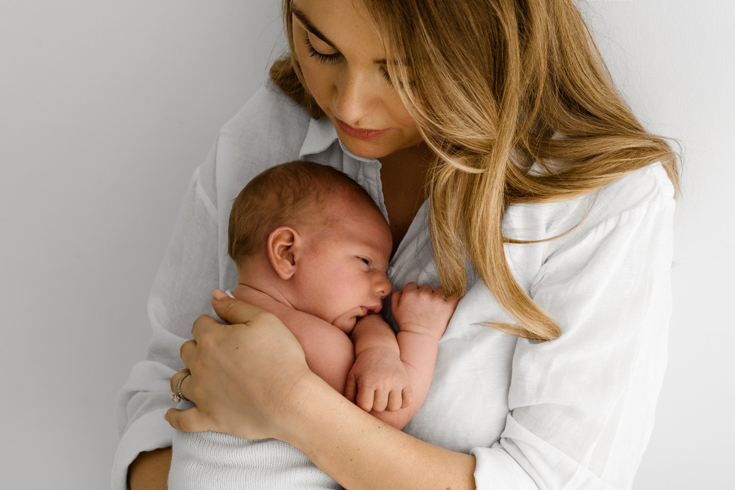 Mum holding her newborn baby during lifestyle newborn photography session