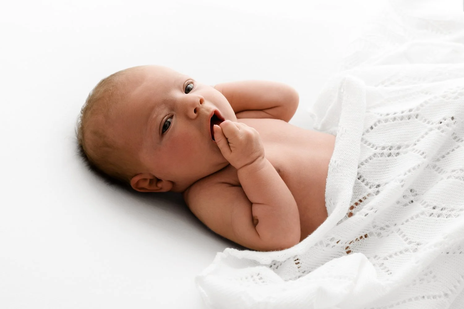 awake newborn in soft lighting in a natural style