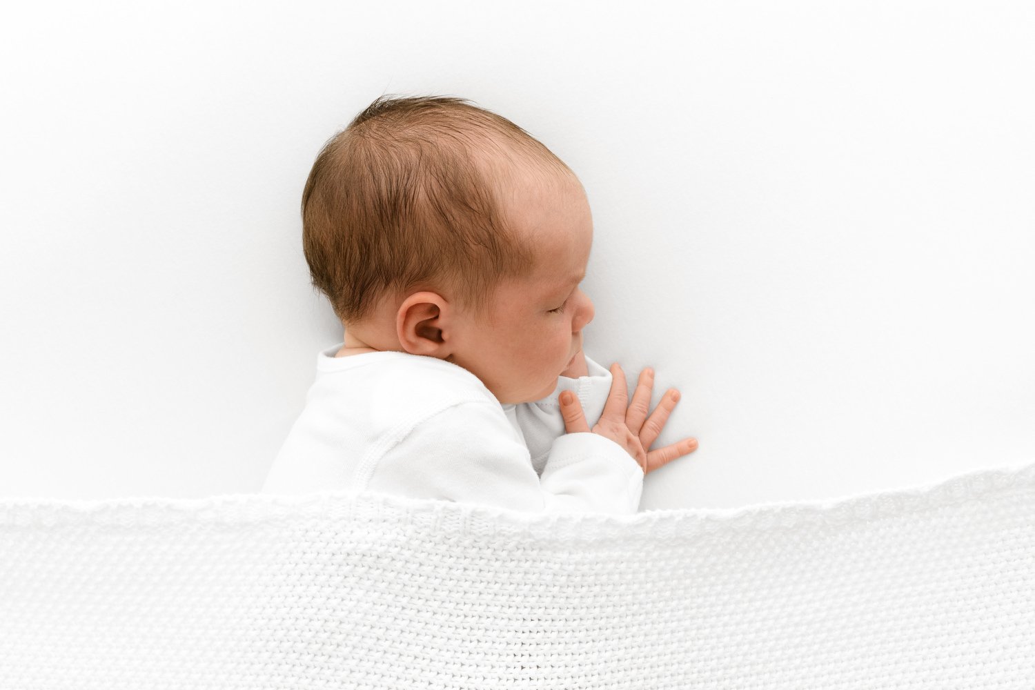 Simple natural newborn photography using soft white blanket and natural lighting