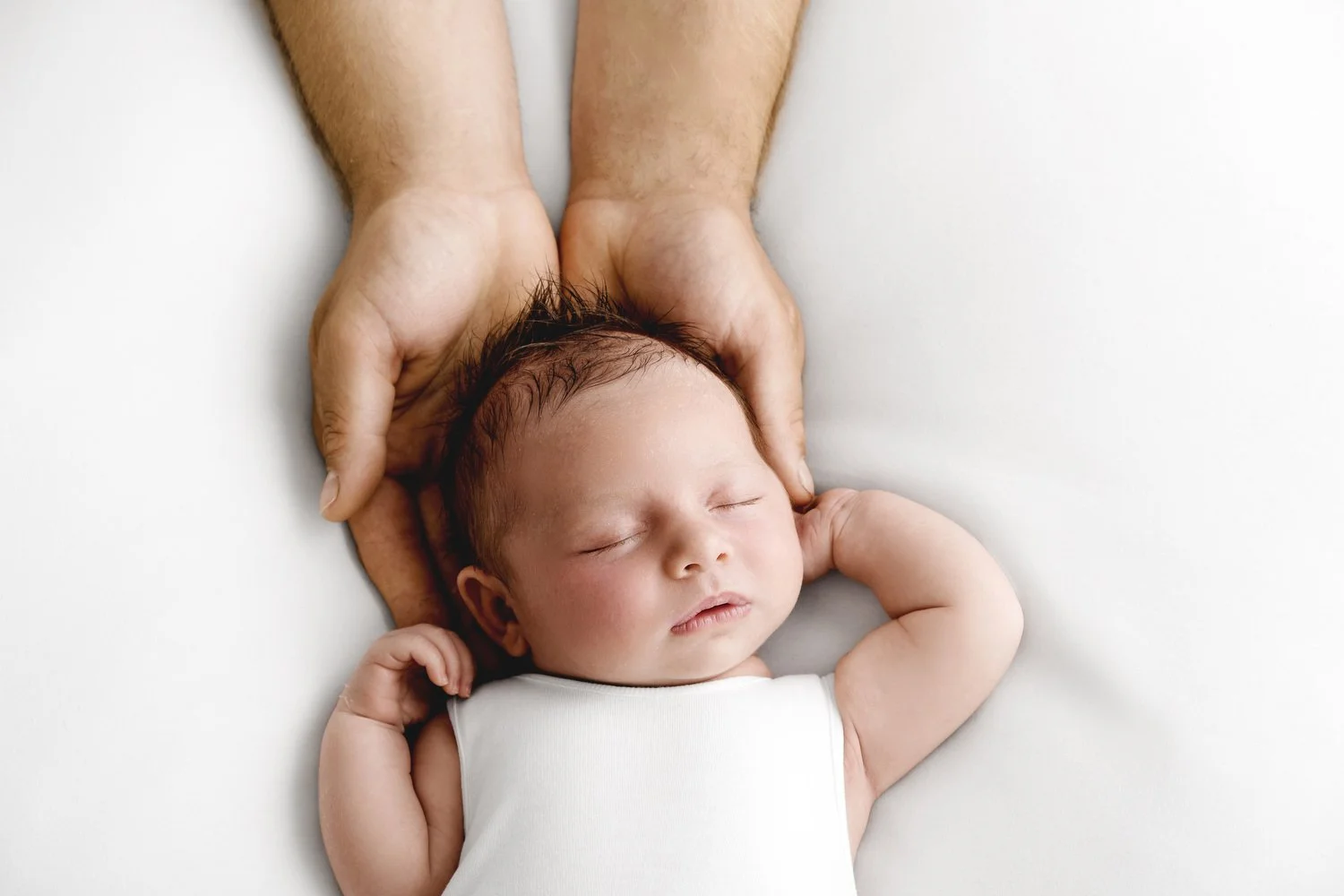 dads hands with newborn baby at Mabel and Moose studio by Ally Stuart-Ross