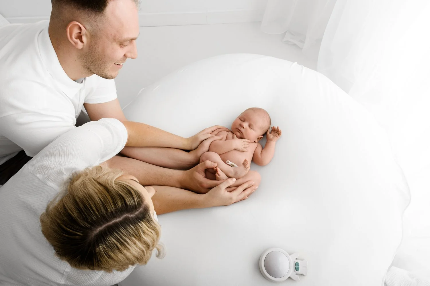 Newborn photography training demonstration showing full studio setup with parents on beanbag