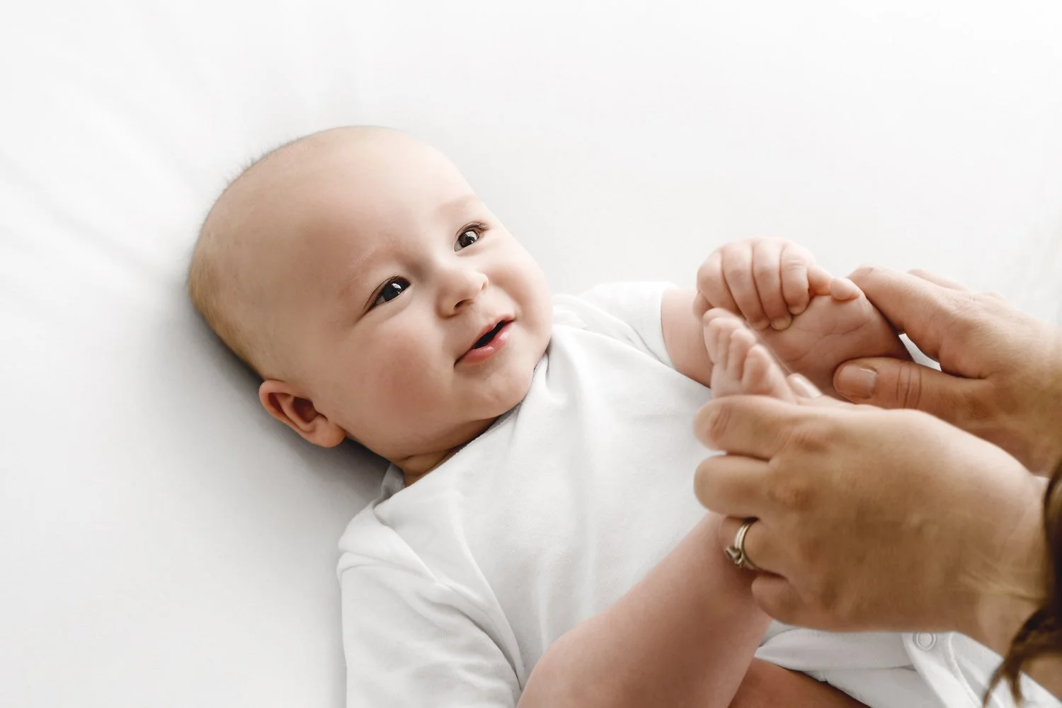 Parent playing with 5 month old baby toes at Mabel and Moose studio by Ally Stuart-Ross