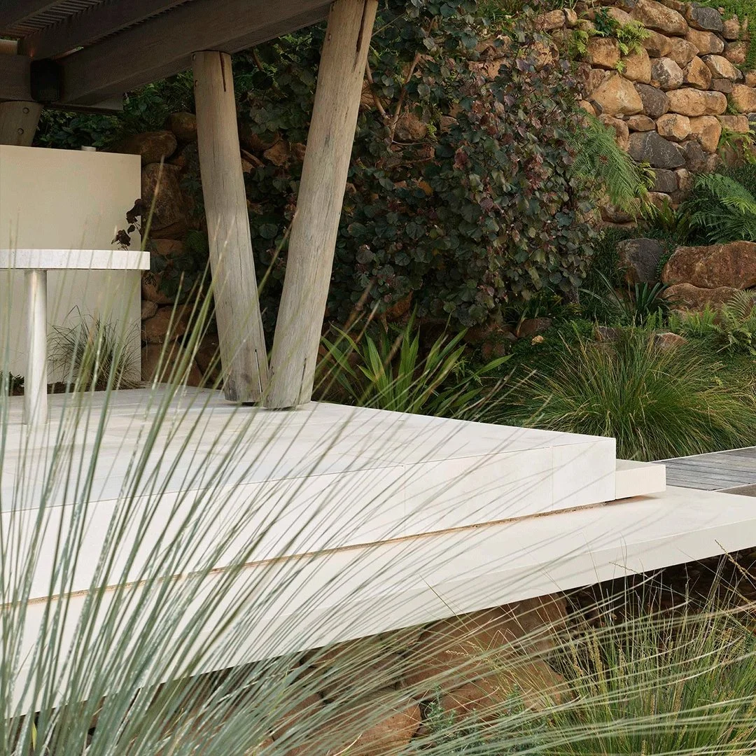 The landscape flows beneath monolithic forms. An oversized cantilevered step extends dramatically, as if floating - architecture responding to nature, and nature shaping architecture.

#Gardensforliving #CoastalHaven #TheTailoredGardener  #LuxuryGard