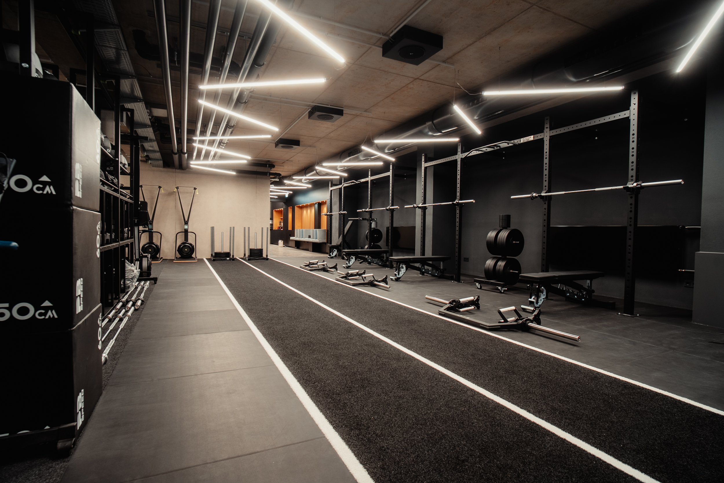 Leerer moderner Fitnessraum mit Laufbahn, Gewichten, Riegeln und Trainingsgeräten