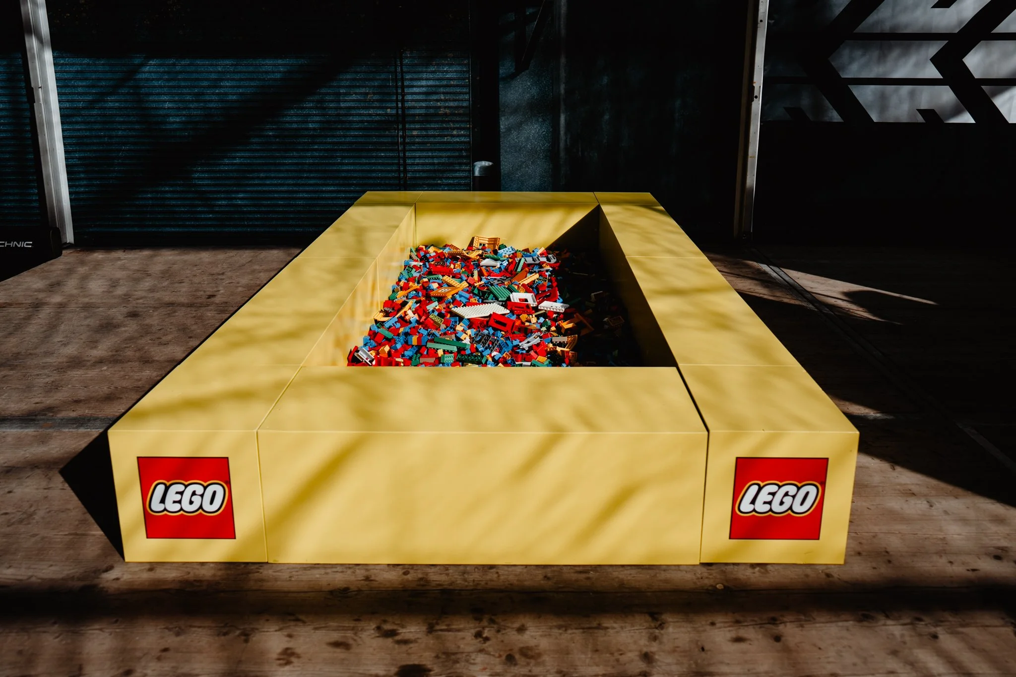 Großer gelber LEGO-Würfel mit LEGO-Steinen in der Mitte, LEGO-Logo an den Seiten