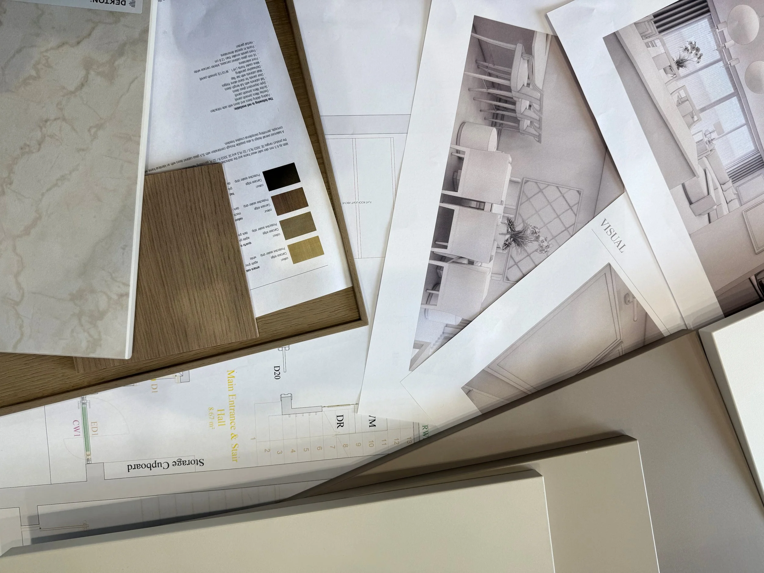 Architectural plans and color swatches for a home interior design project spread out on a table.