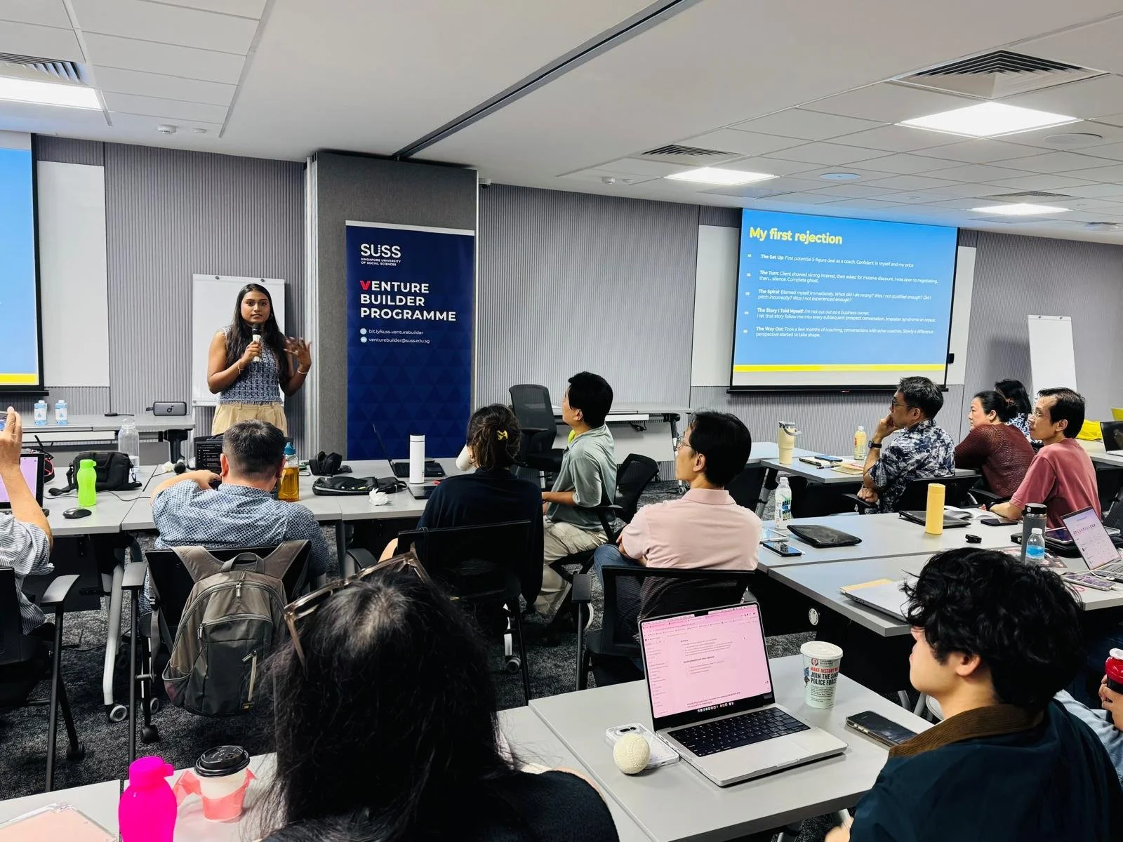 Founder of ItsGabby Marketing company presenting at a conference or seminar in a modern room with Several attendees seated, listening. The event is part of SUSS University in Singapore and theirVenture Builder Programme.