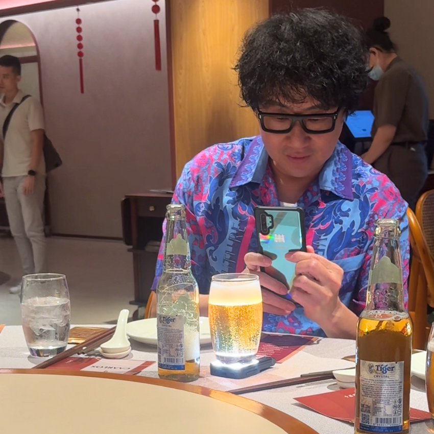 An influncer at an event taking photo of tiger beer