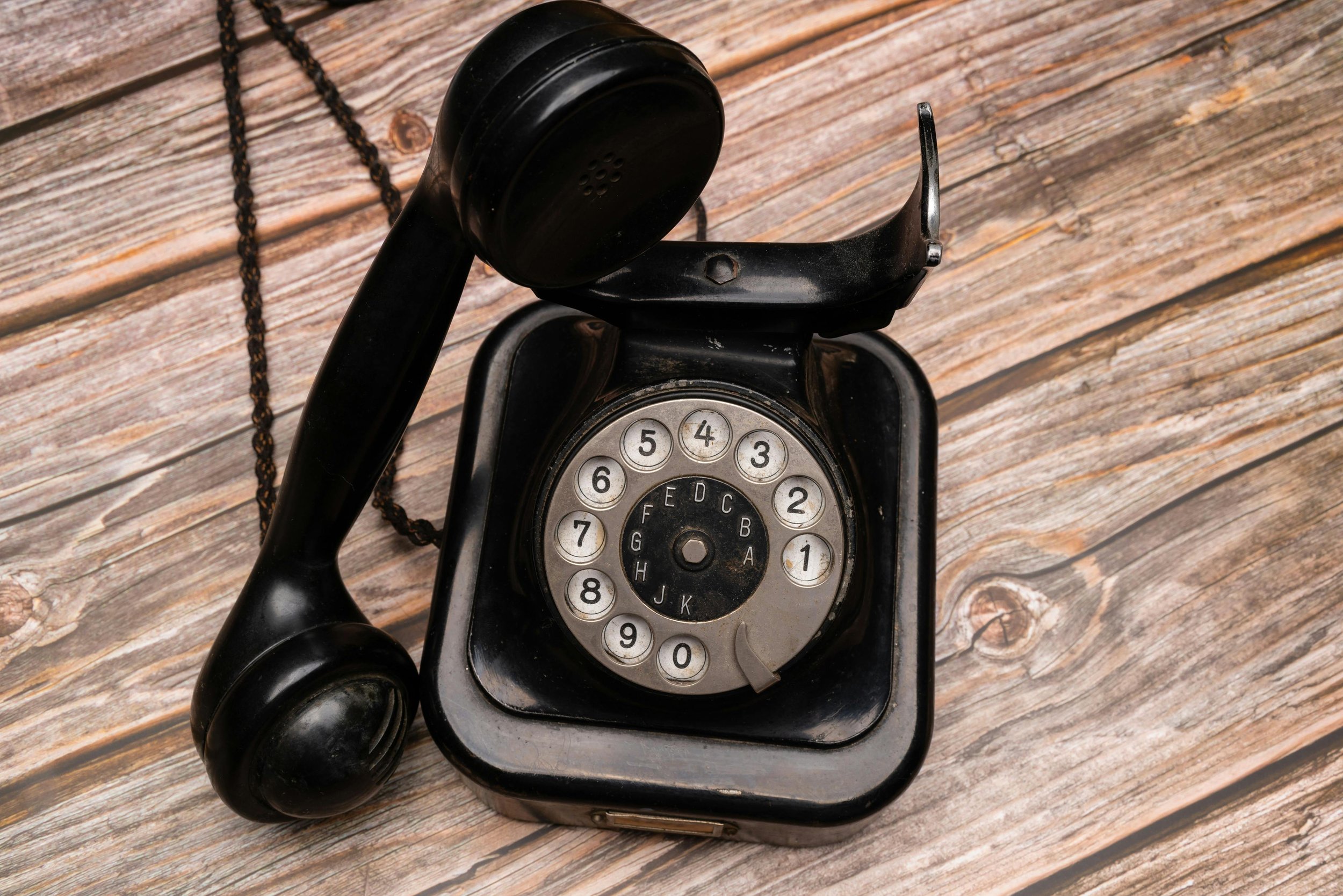 An old fashioned telephone with the receiver off the hook