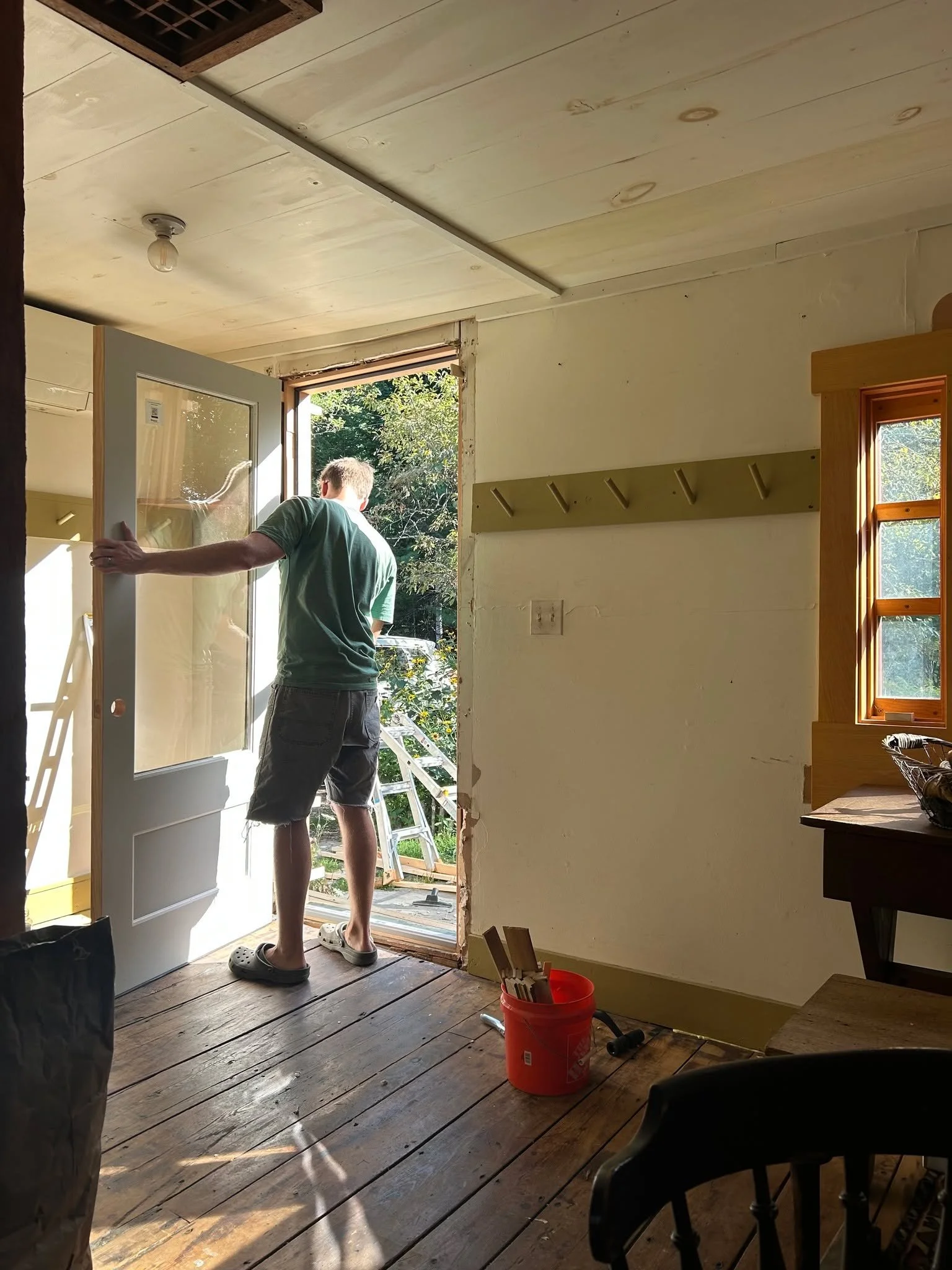 Daniel putting up a big beam over our woodstove and installing the new exterior kitchen door.
