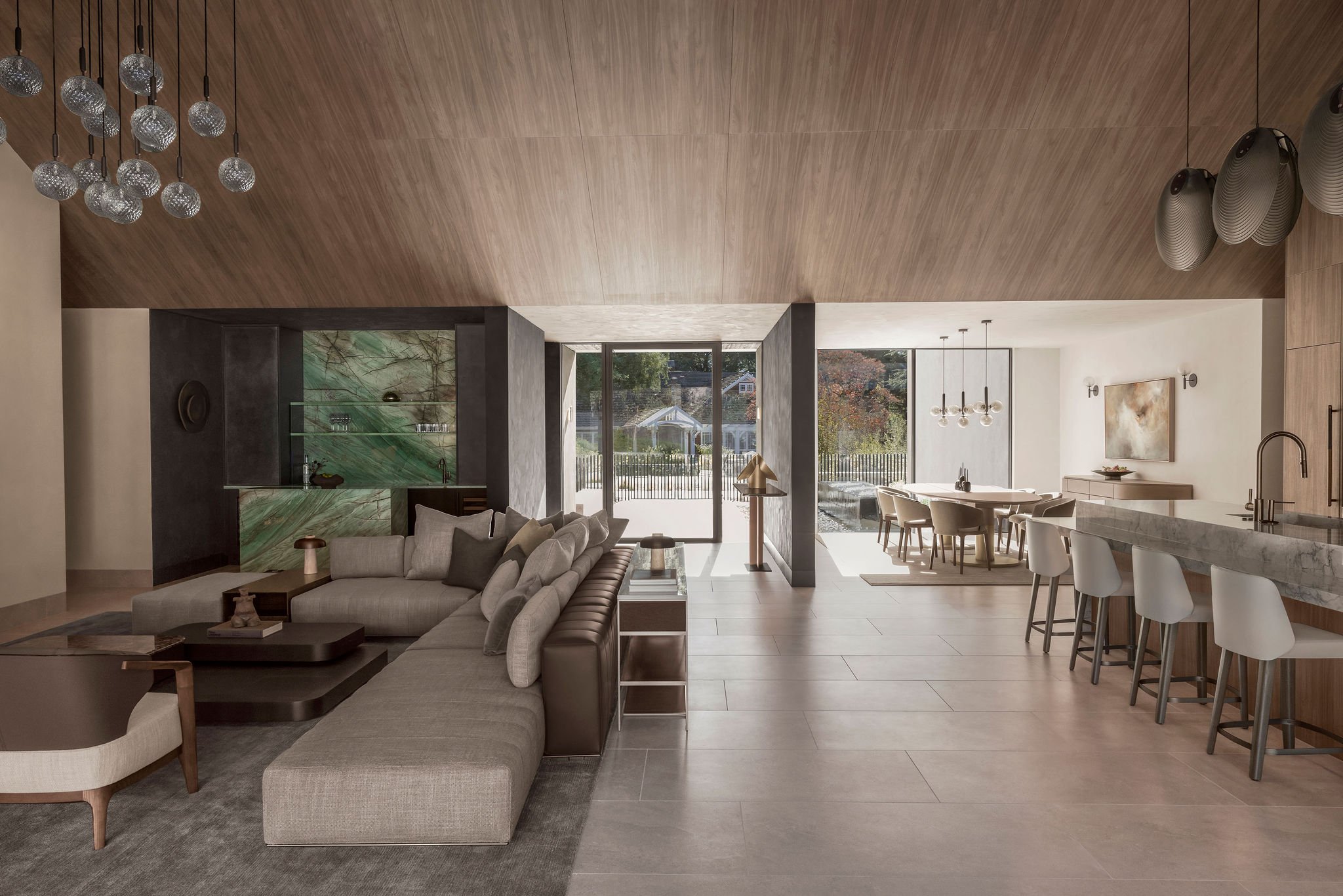 Modern great room looking into home entry, cabinet paneled vaulted ceiling, moody bar, warm inviting dining room