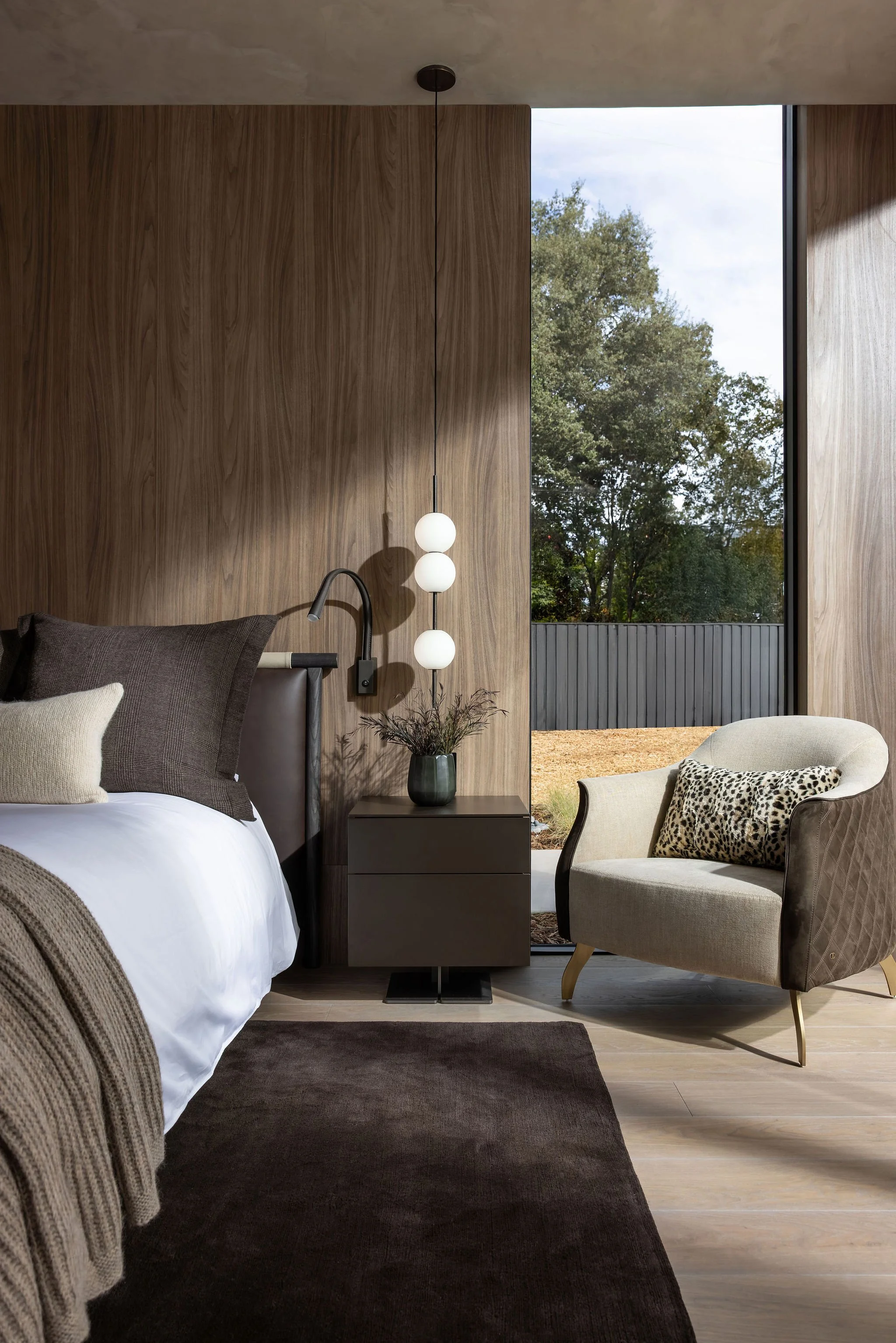 Modern primary bedroom with cabinet paneled headboard wall