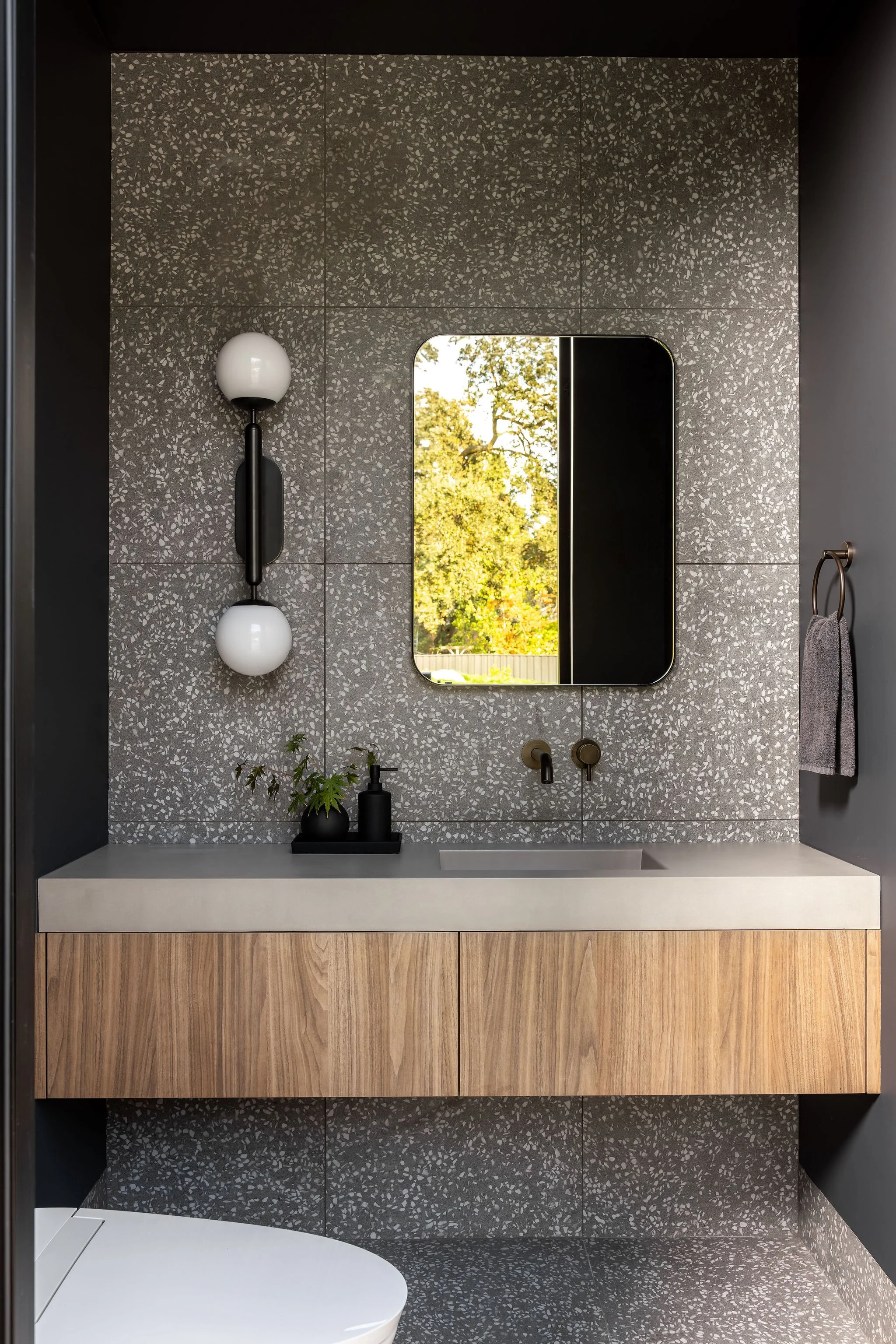 Modern exterior powder / pool bath with floating cabinet vanity and full width concrete sink and terrazzo tile
