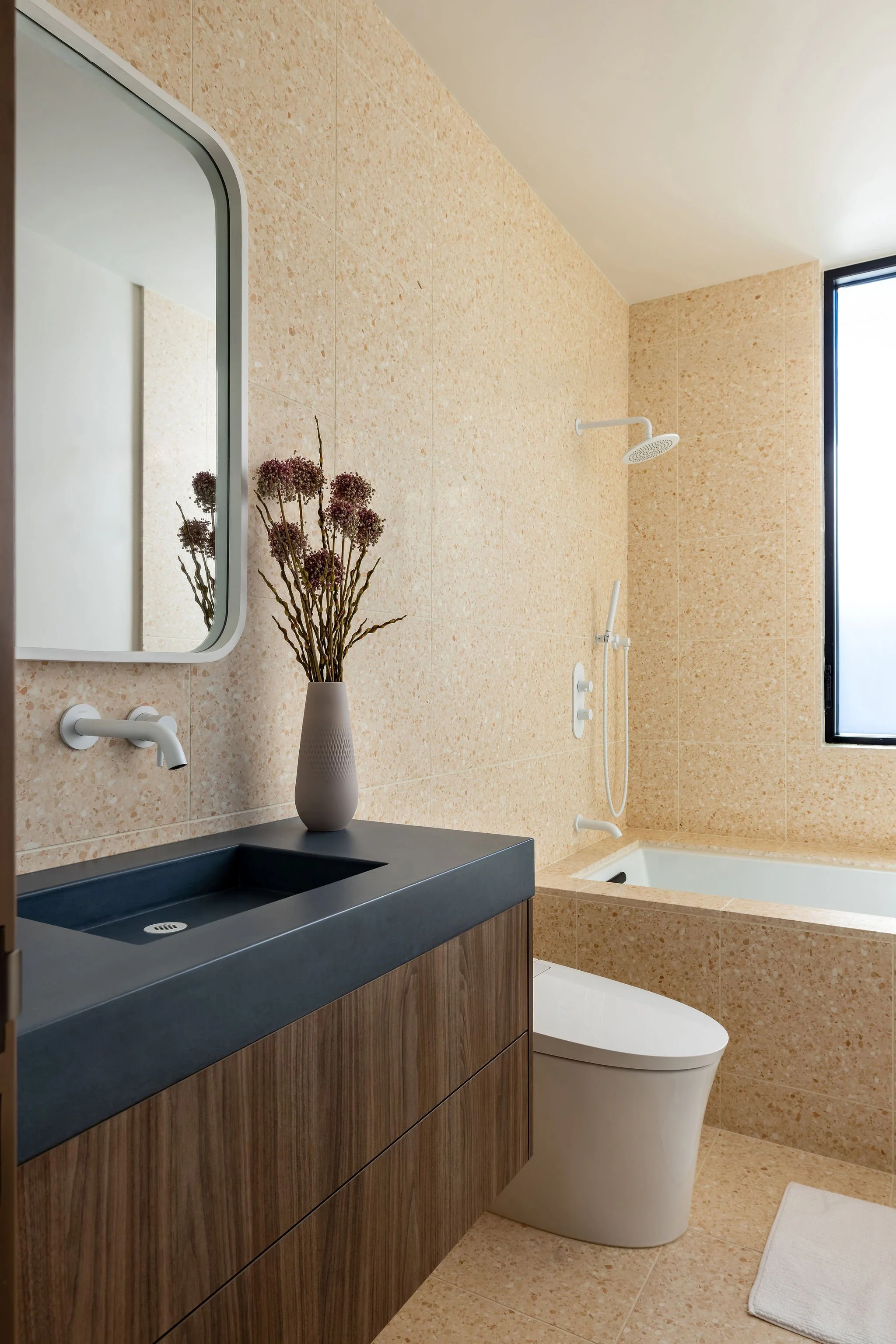 Cute modern kid's bathroom with floating cabinet vanity, terrazzo tile and white fixtures