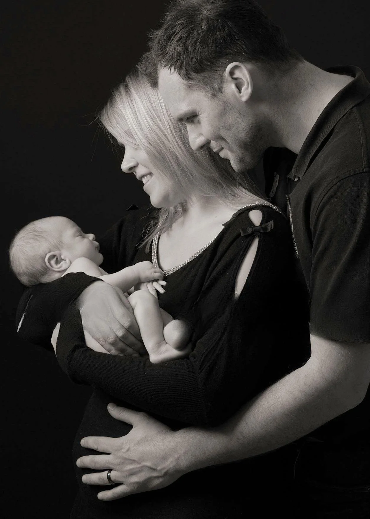 Black and White portrait of Mother and father holding their baby