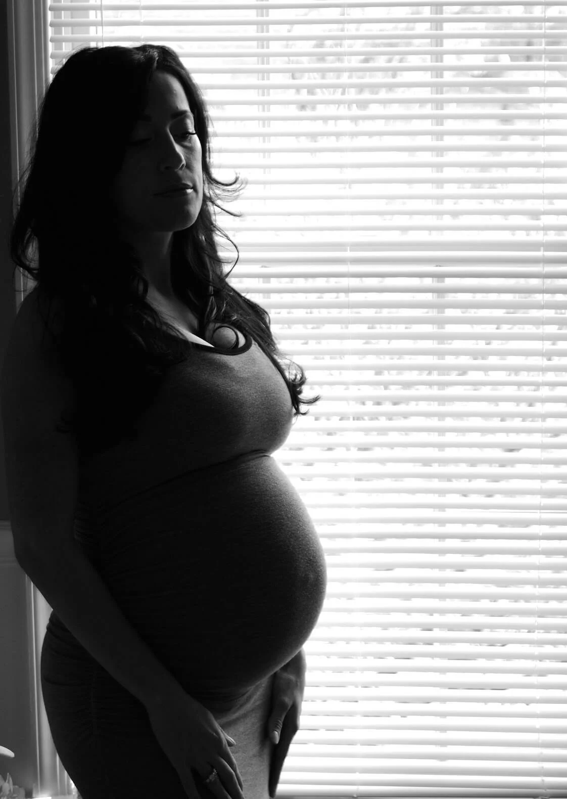 Black and white portrait of pregnant woman in front of window - maternity photography