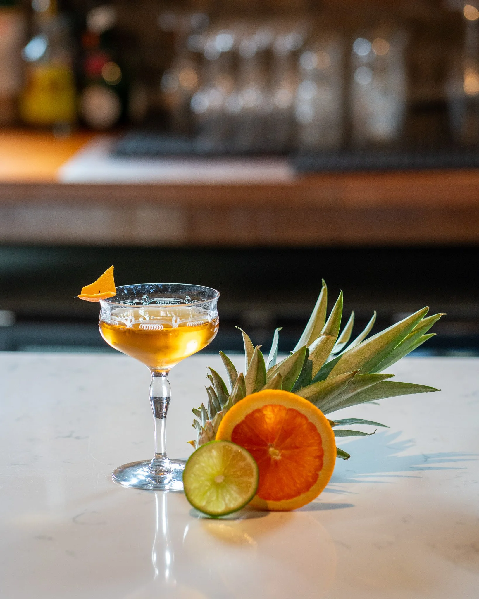 Custom cocktail with grapefruit, lime and pineapple garnishes