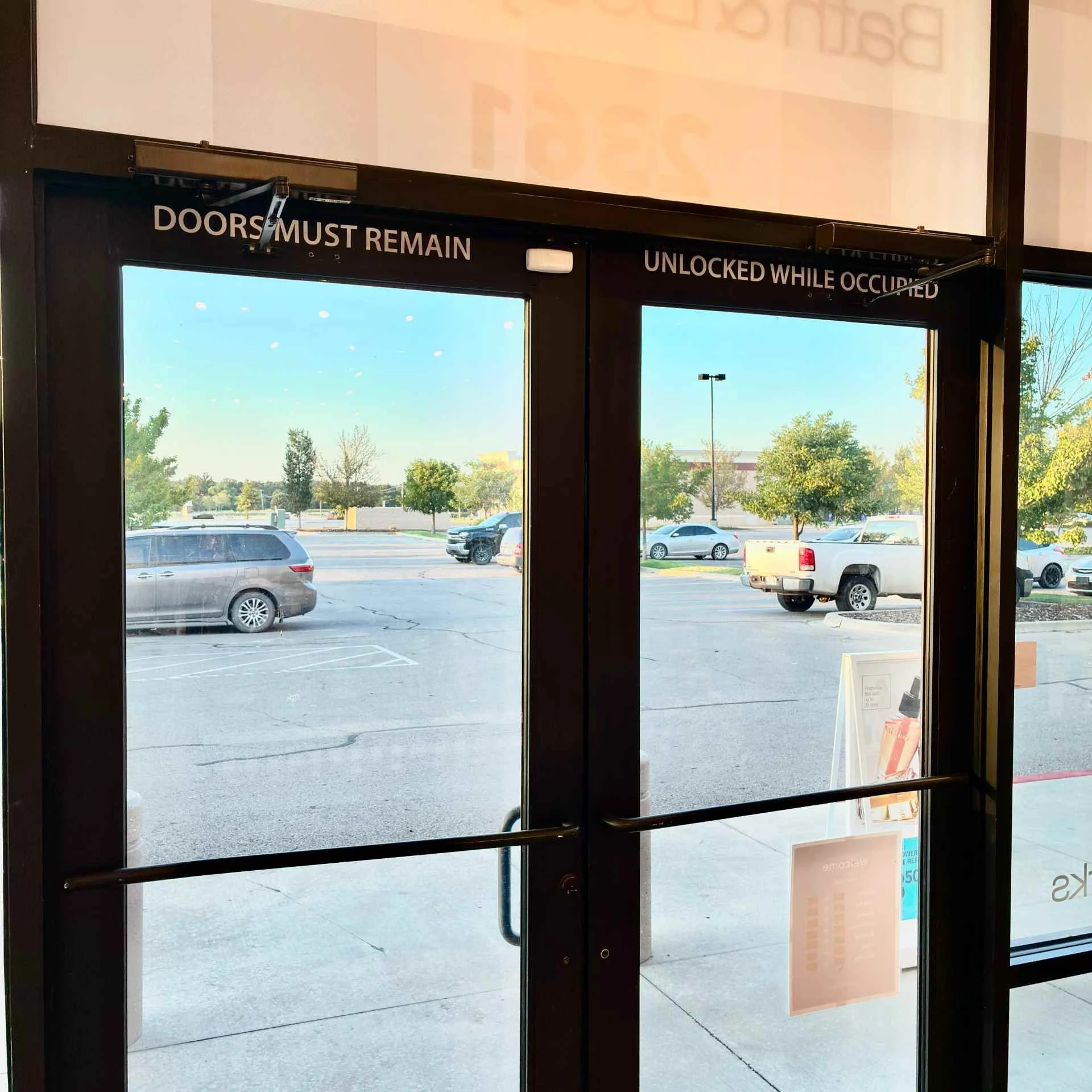 Two new commercial door closers installed on aluminum storefront doors at a retail store in Bartlesville, Oklahoma.