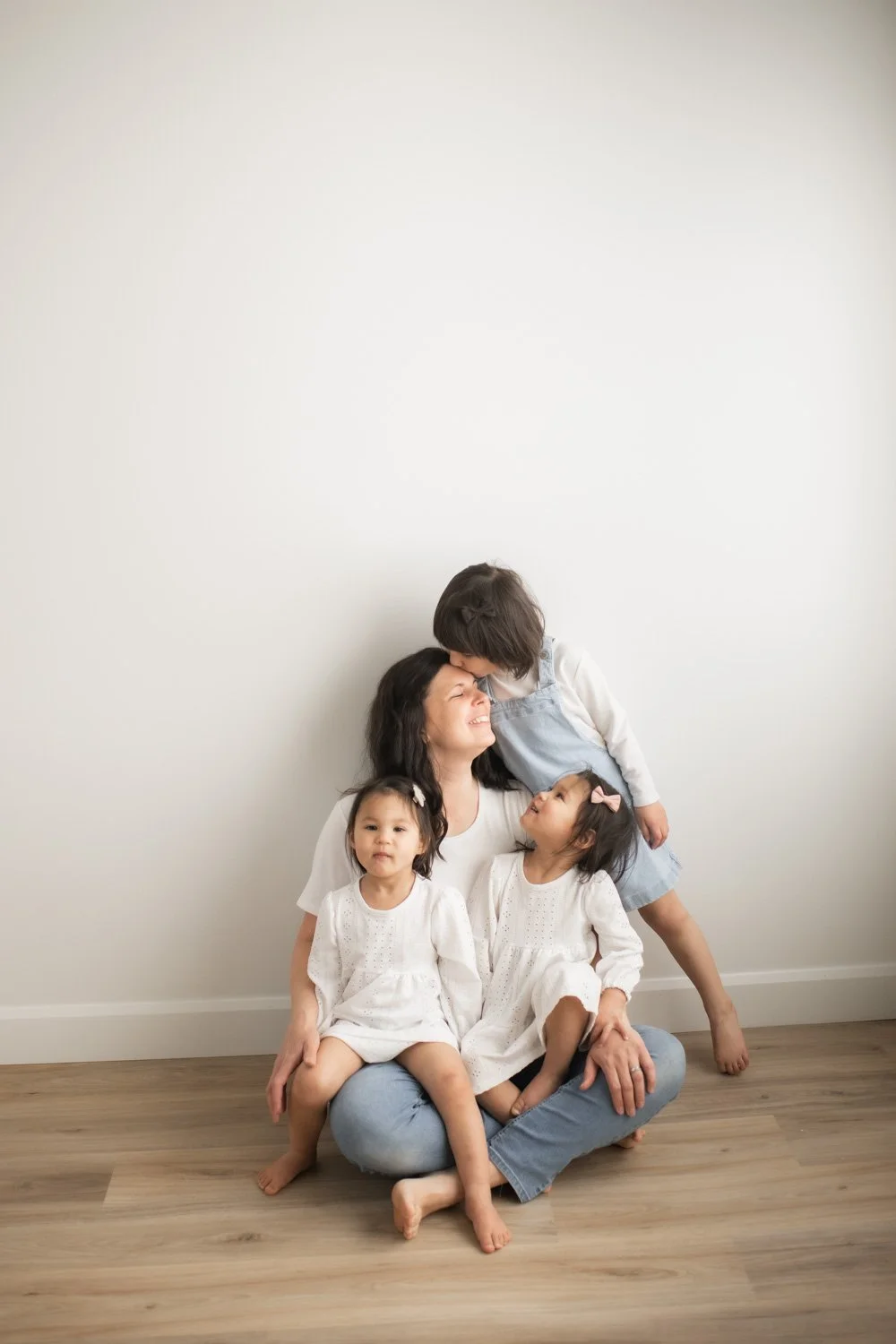 mom and daughters, girl kissing moms head studio photo