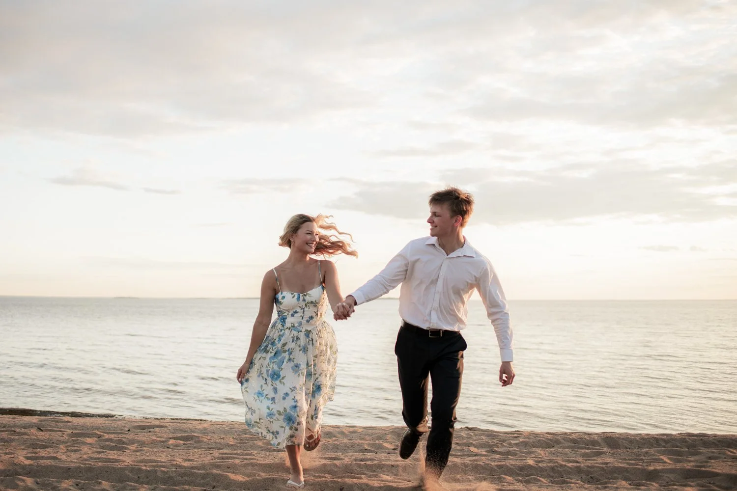 engagement photos, couple running from the beach at sunset