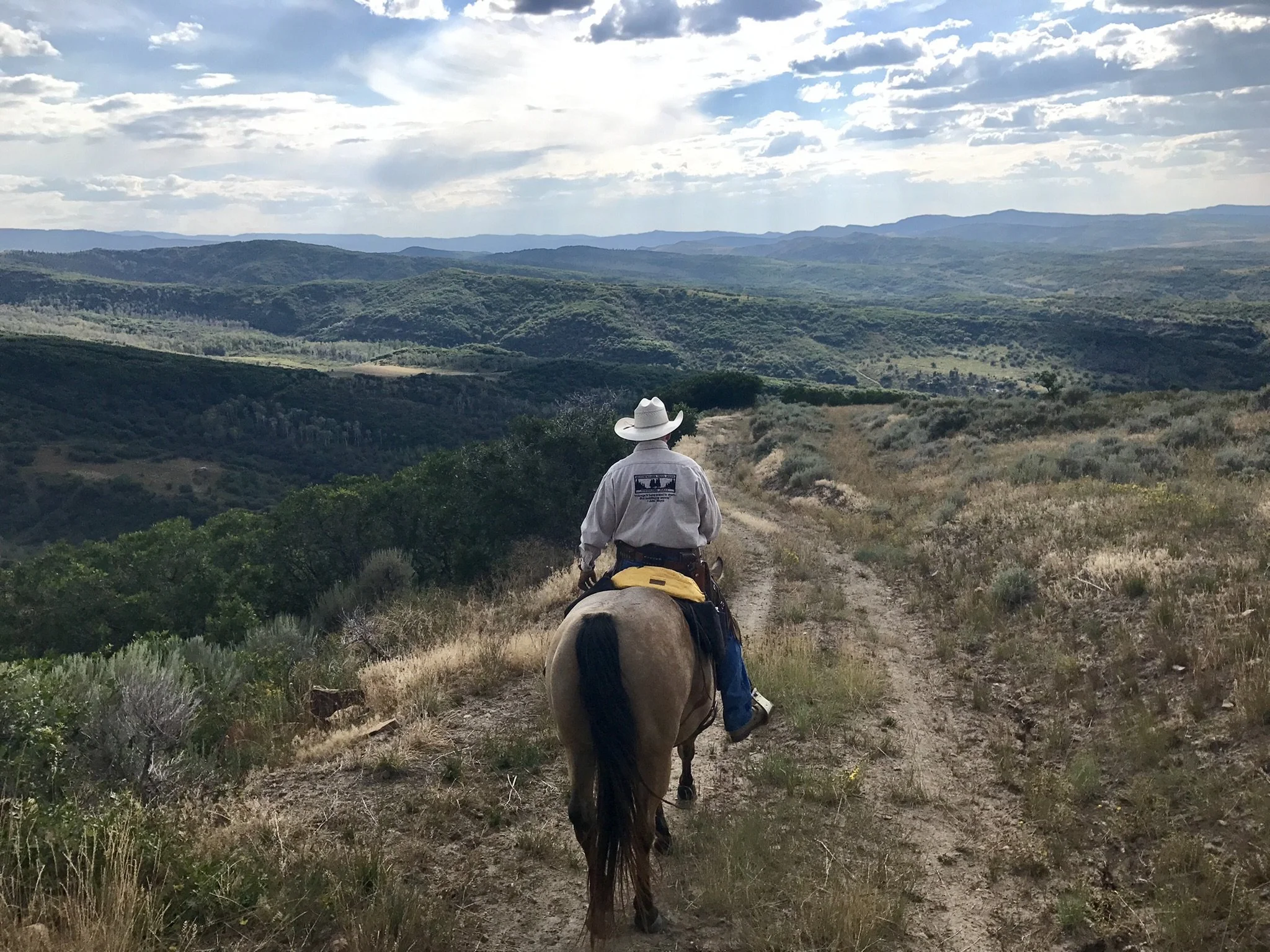 34. RV - Jeff riding on top of mountain grey shirt and yellow bag on horse.jpeg