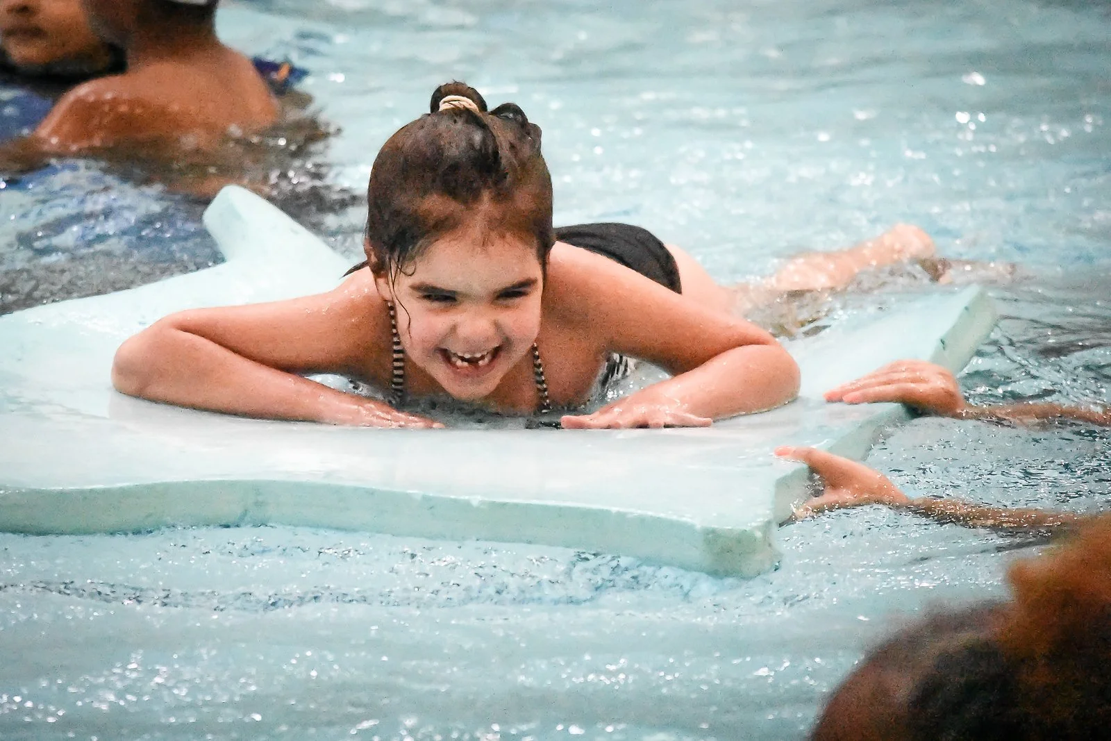 Girl Swimming with Teacher in Pool